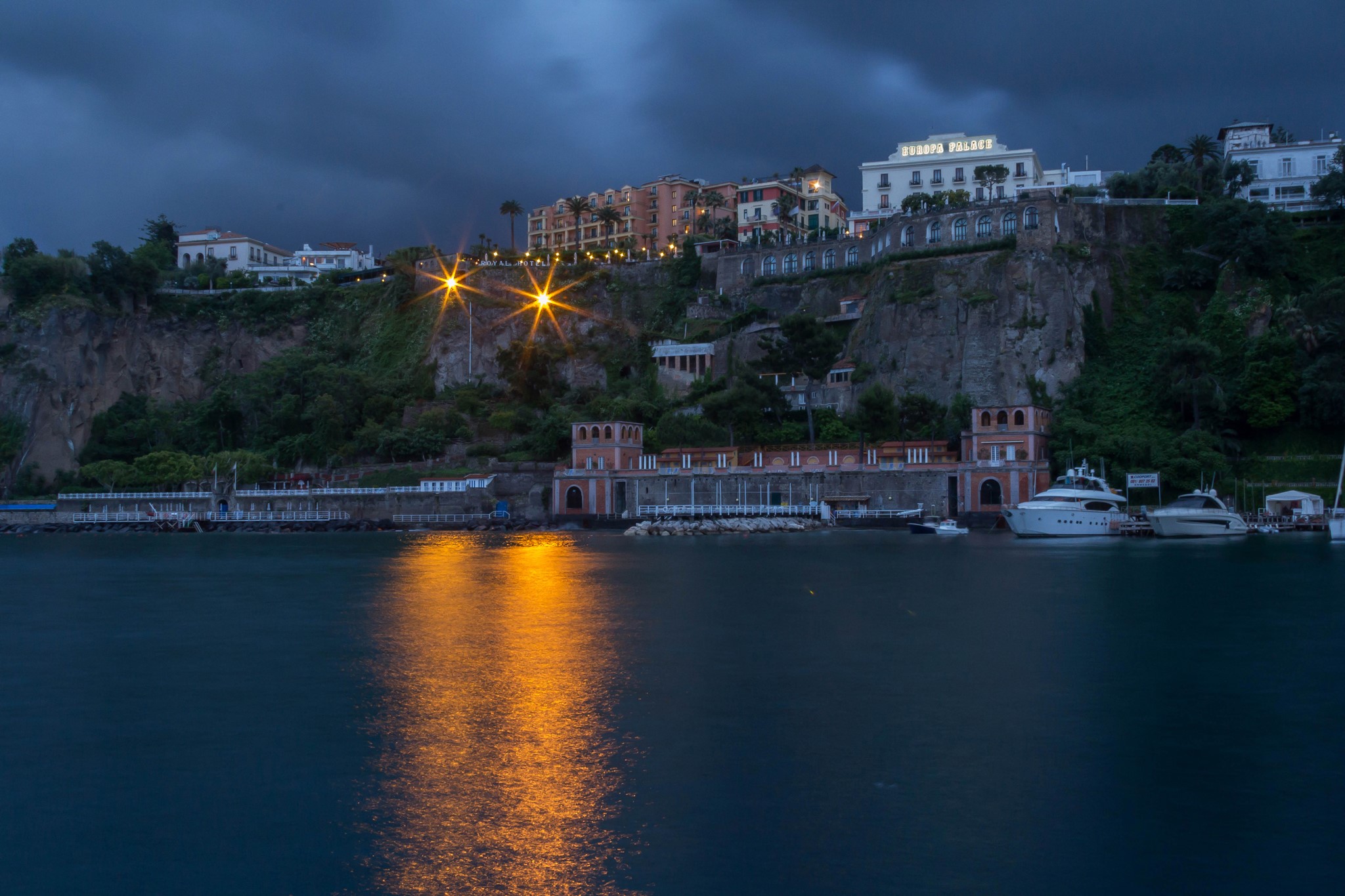 Sorrento Italy cliffside buildings and yachts at dusk HD Wallpaper