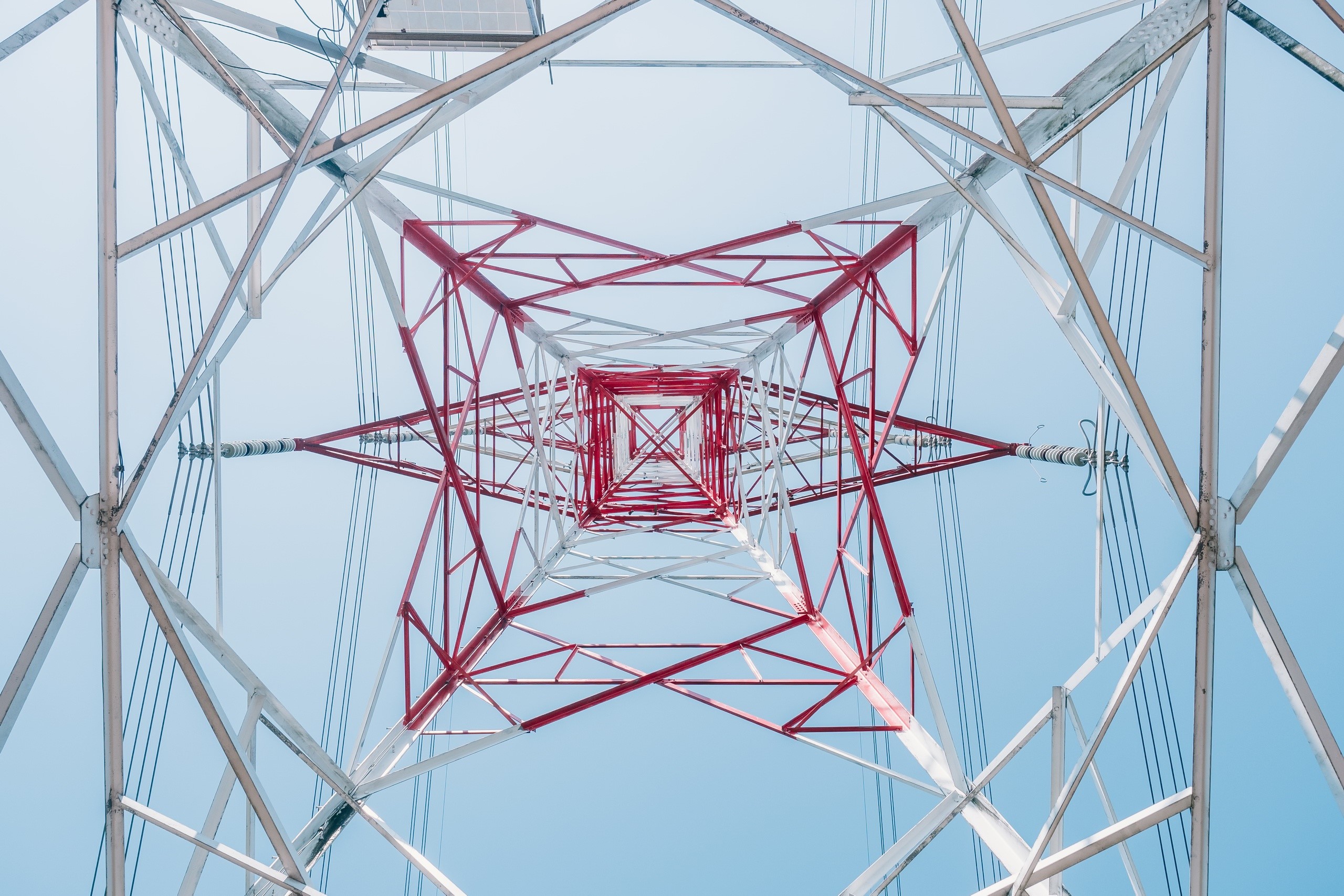 Looking up at a red and white power line tower HD Wallpaper