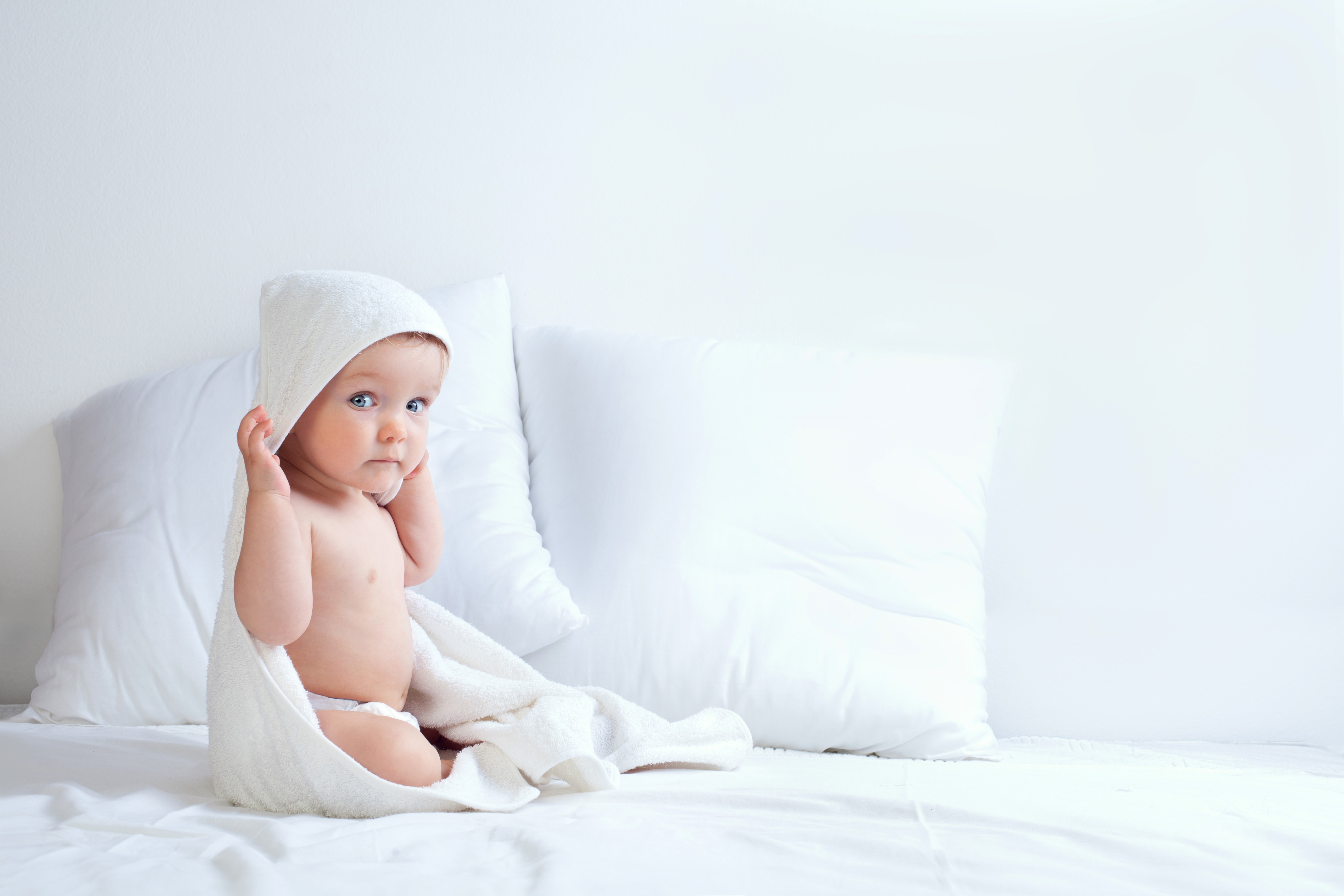 Infant wrapped in a towel with pillows HD Wallpaper
