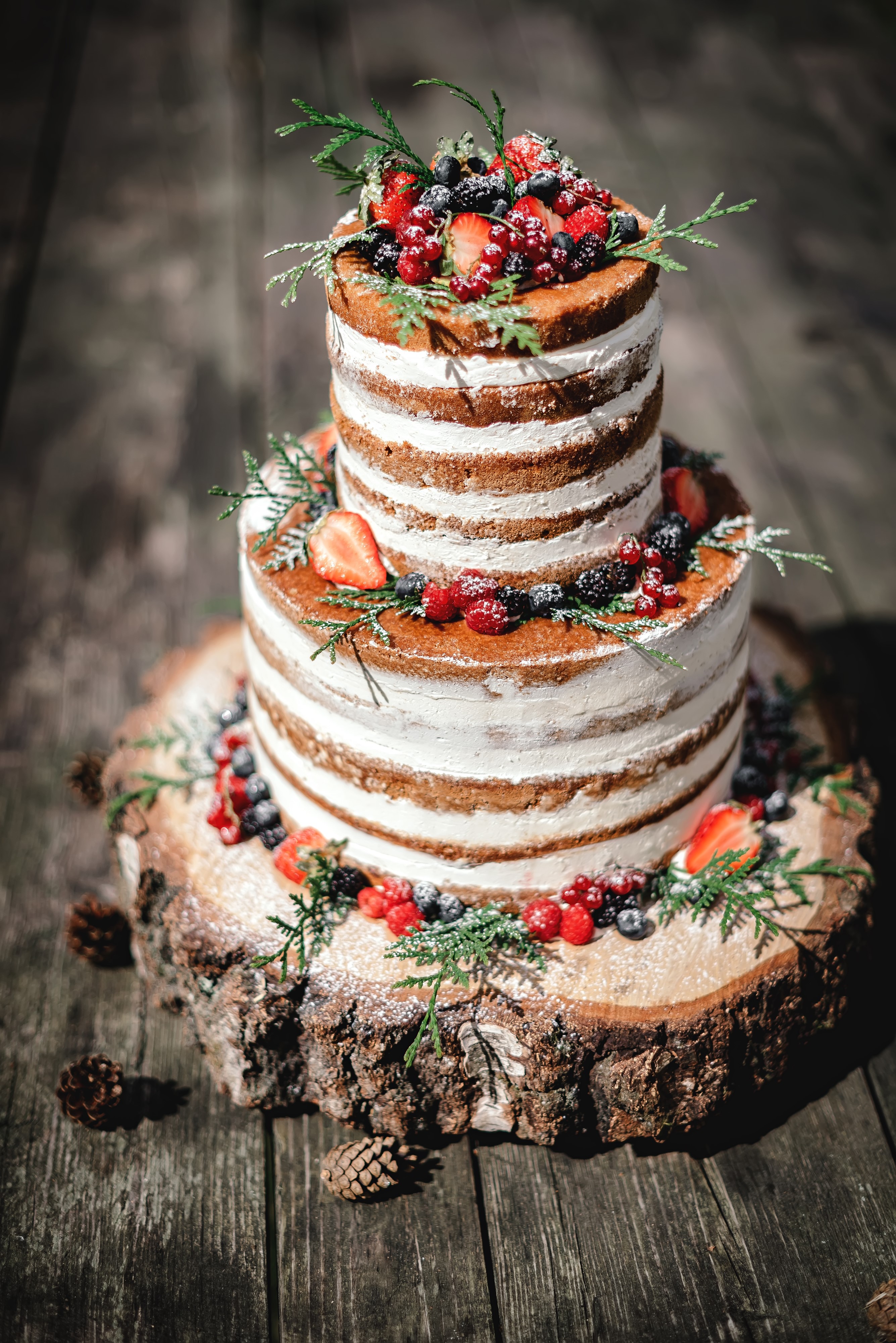 Two-tiered naked cake with berries and greenery HD Phone Wallpaper