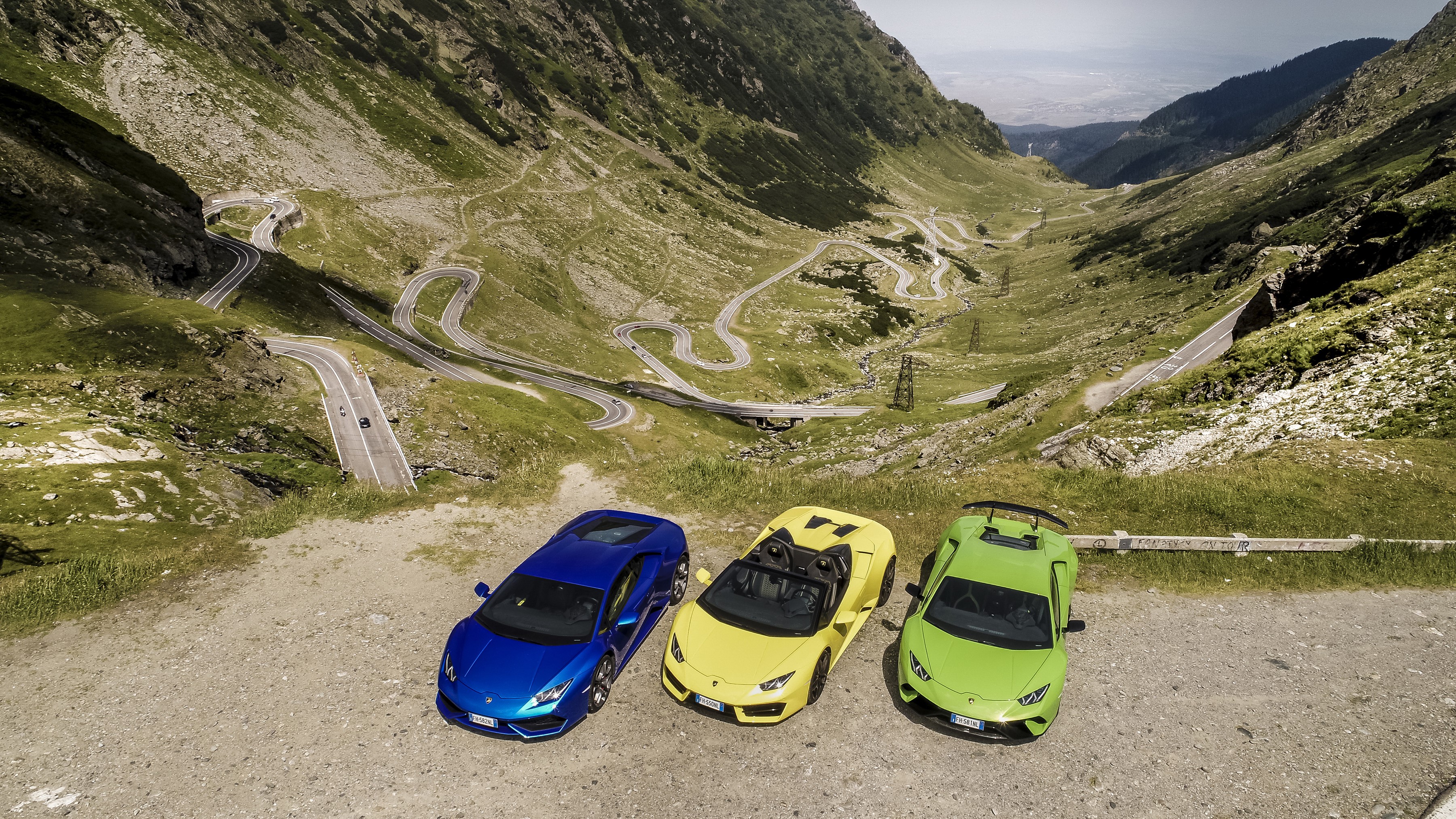 Three Lamborghinis on a winding mountain road HD Wallpaper
