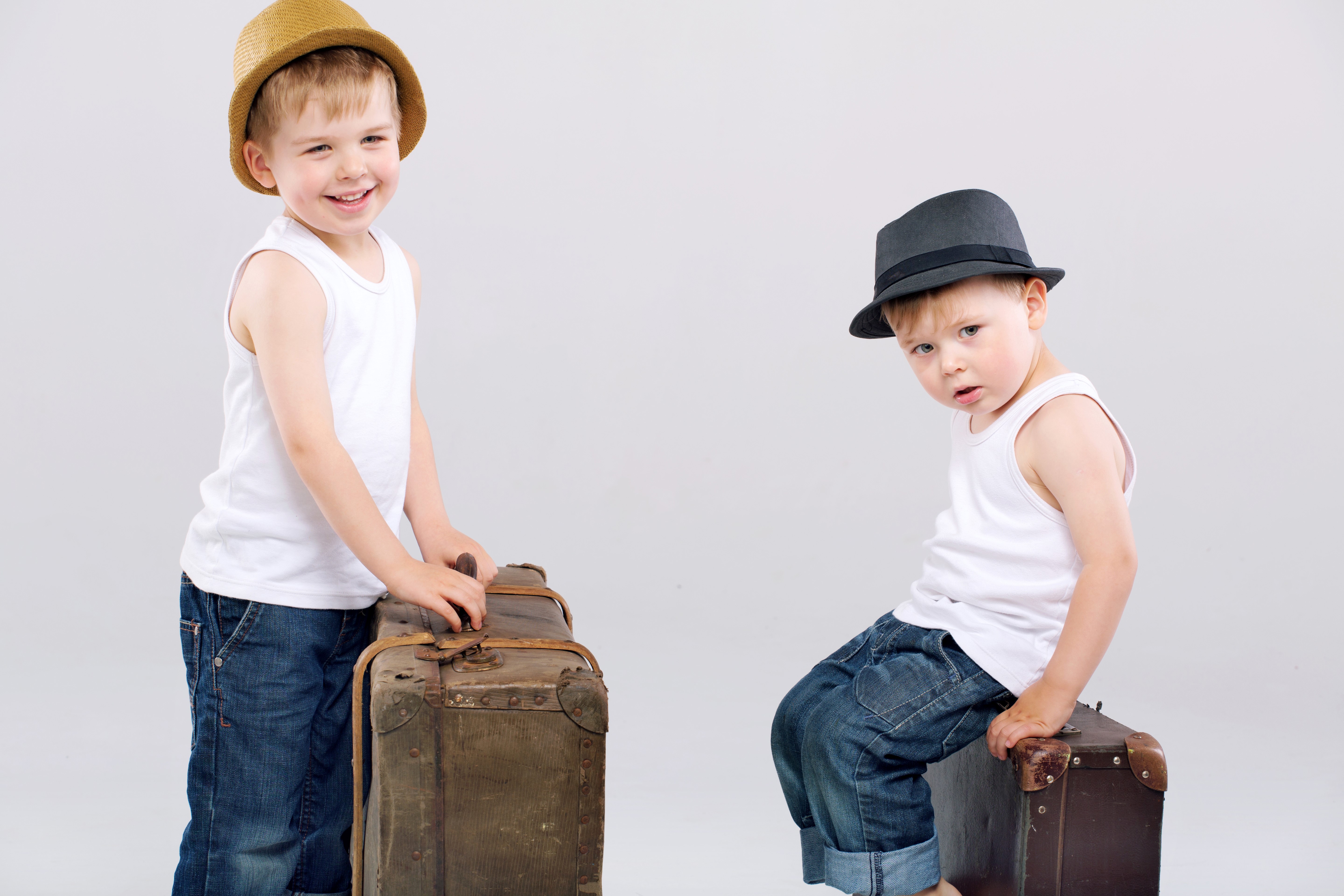 Two boys with hats and suitcases HD Wallpaper