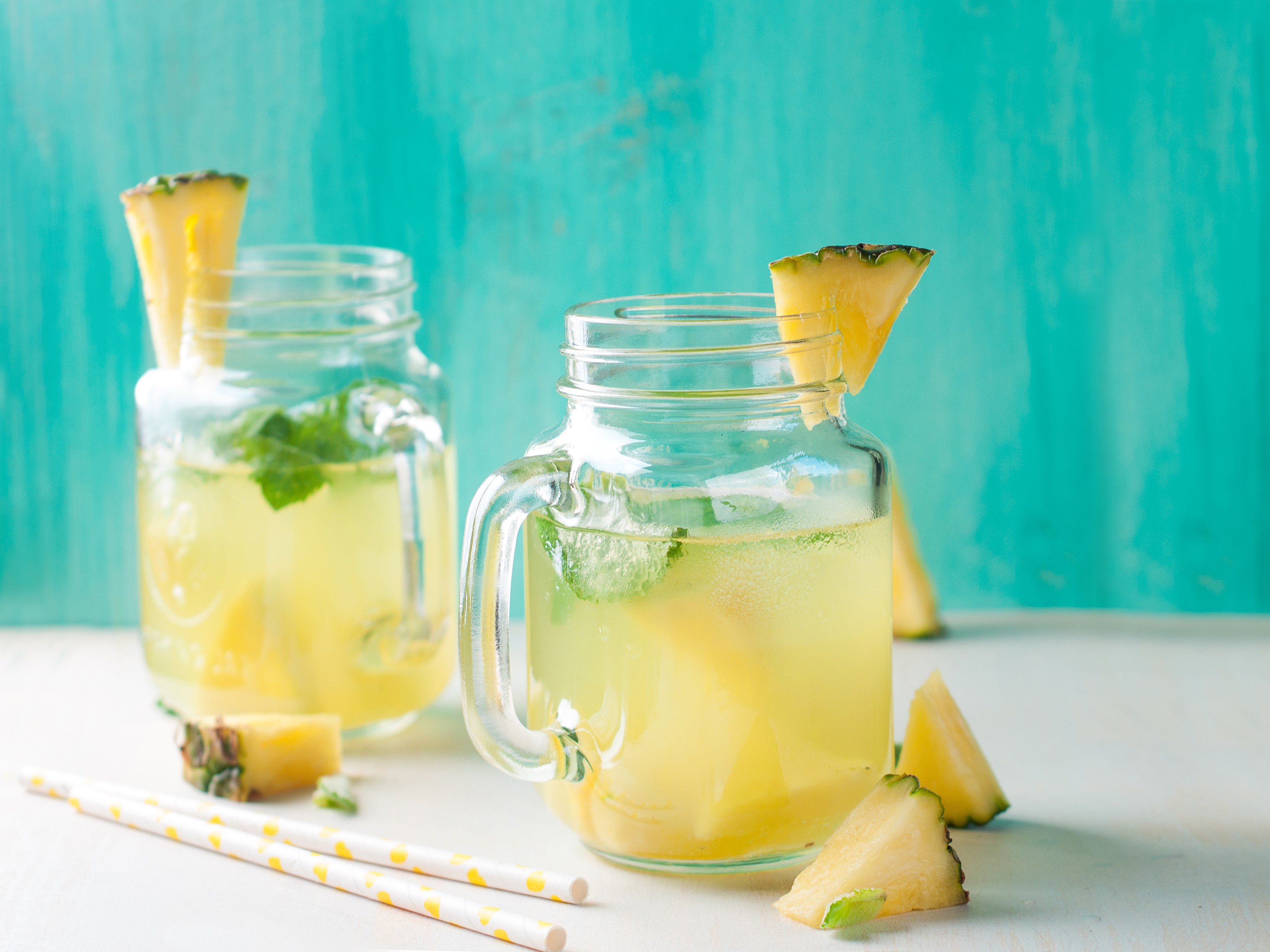 Two pineapple juice drinks in mason jars with mint HD Wallpaper