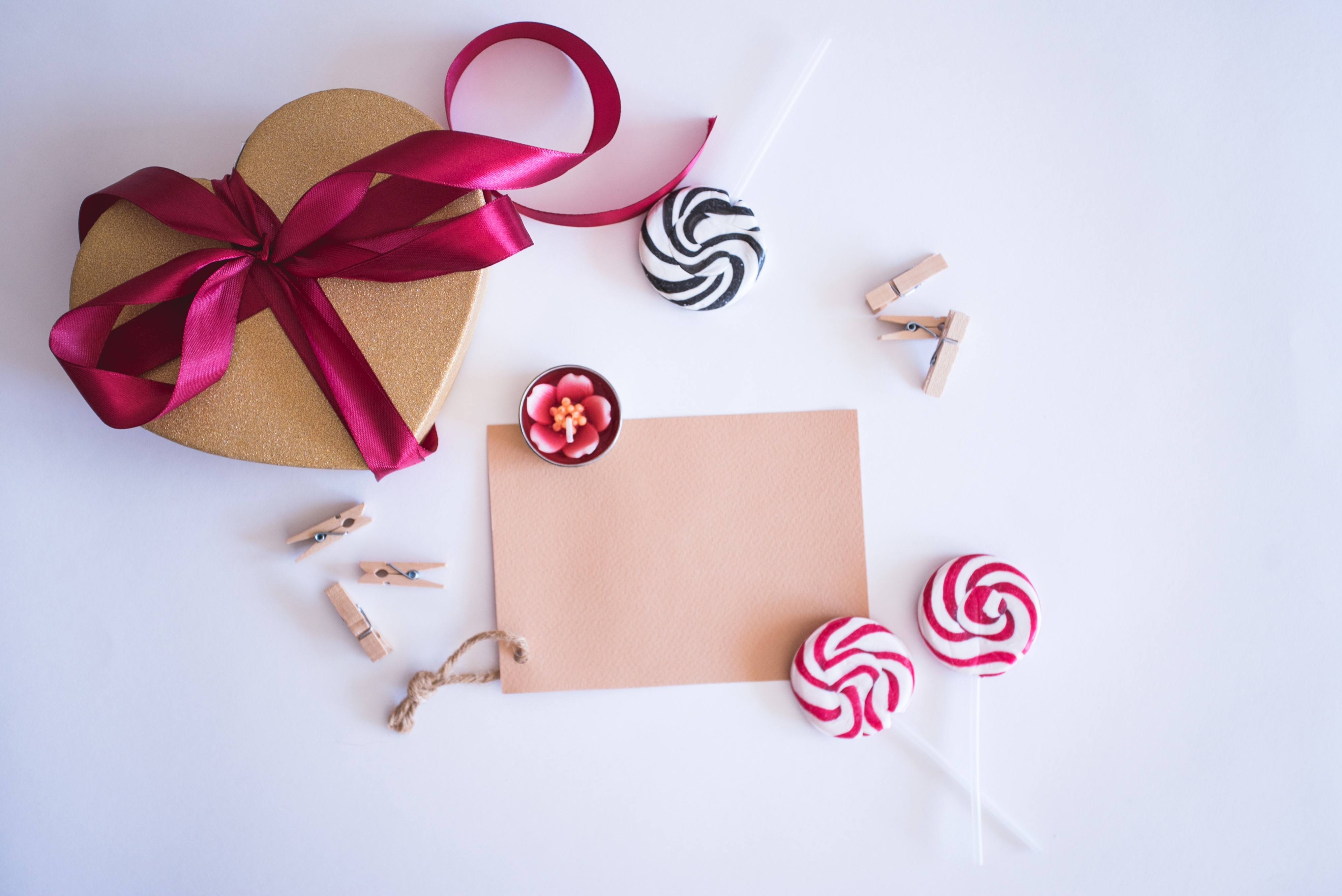 Heart-shaped gift box with ribbon, lollipops, and card HD Wallpaper
