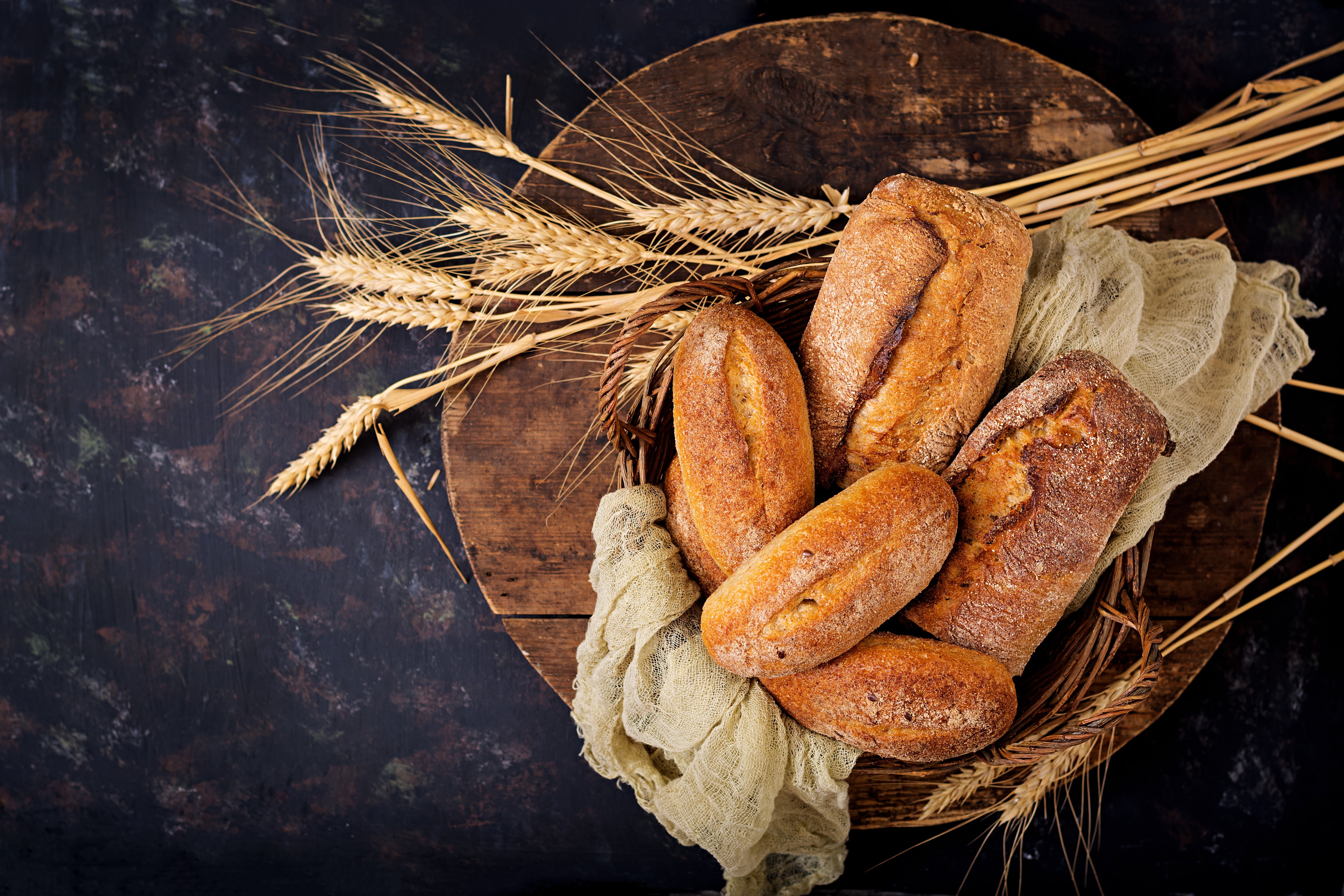 Bread and wheat stalks on a wooden board HD Wallpaper