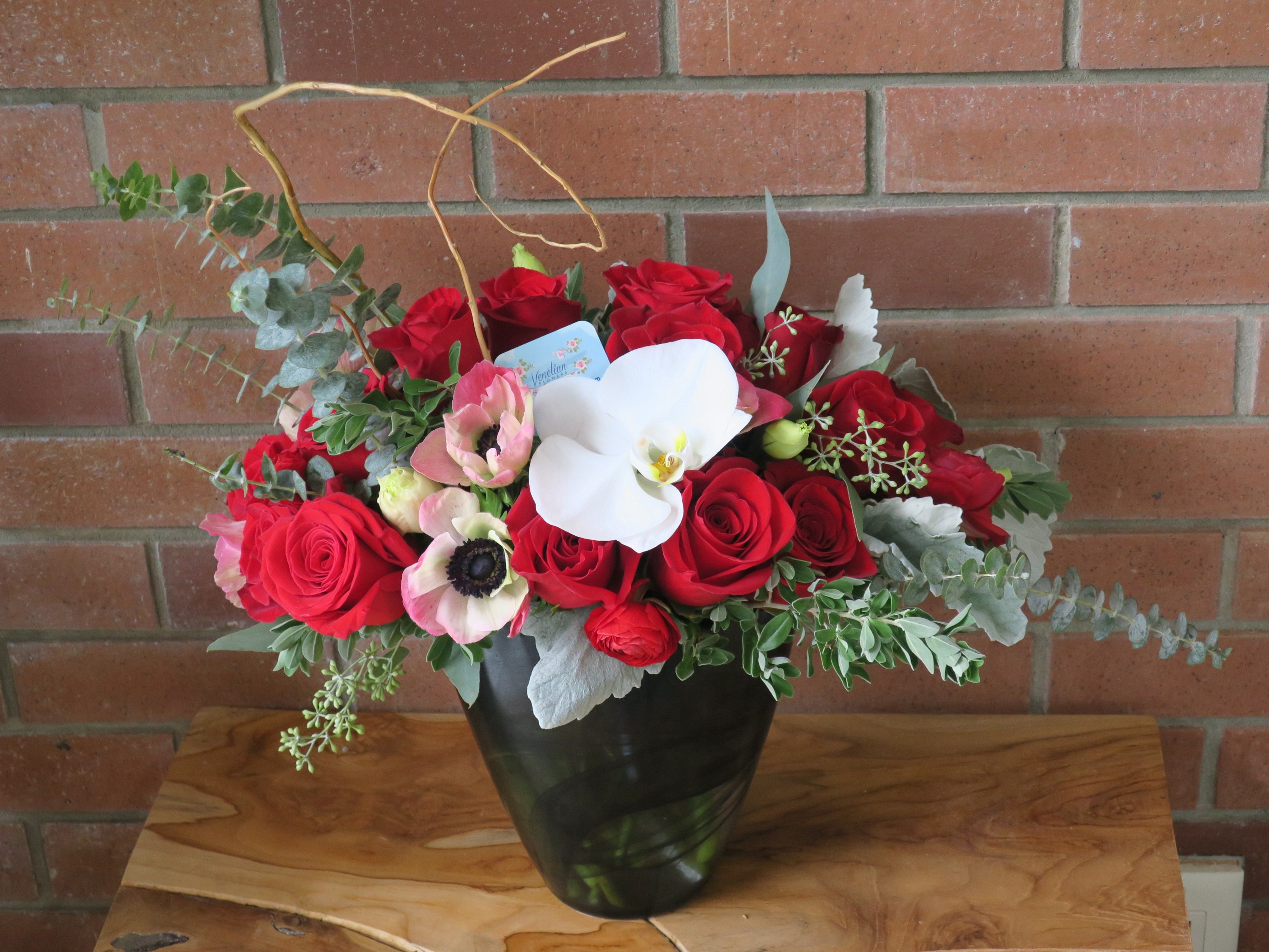 Red roses, anemones, and orchid in a black vase HD Wallpaper