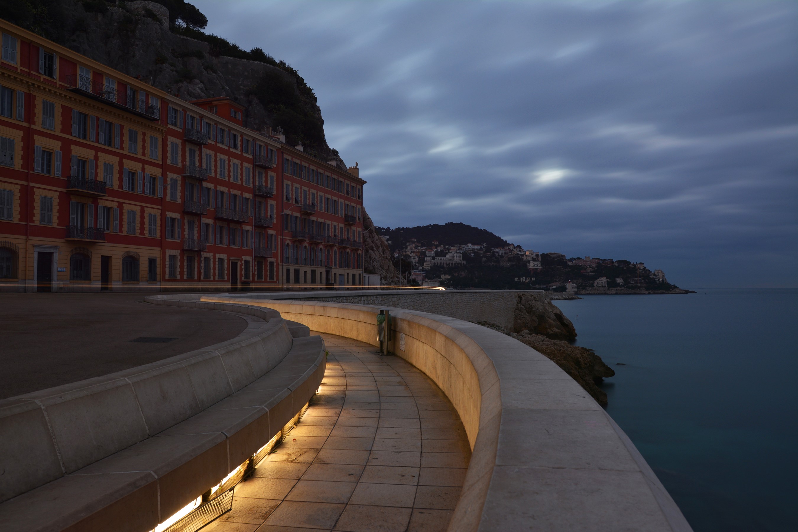 Buildings on a cliff overlooking the sea at dusk in Nice, France HD Wallpaper