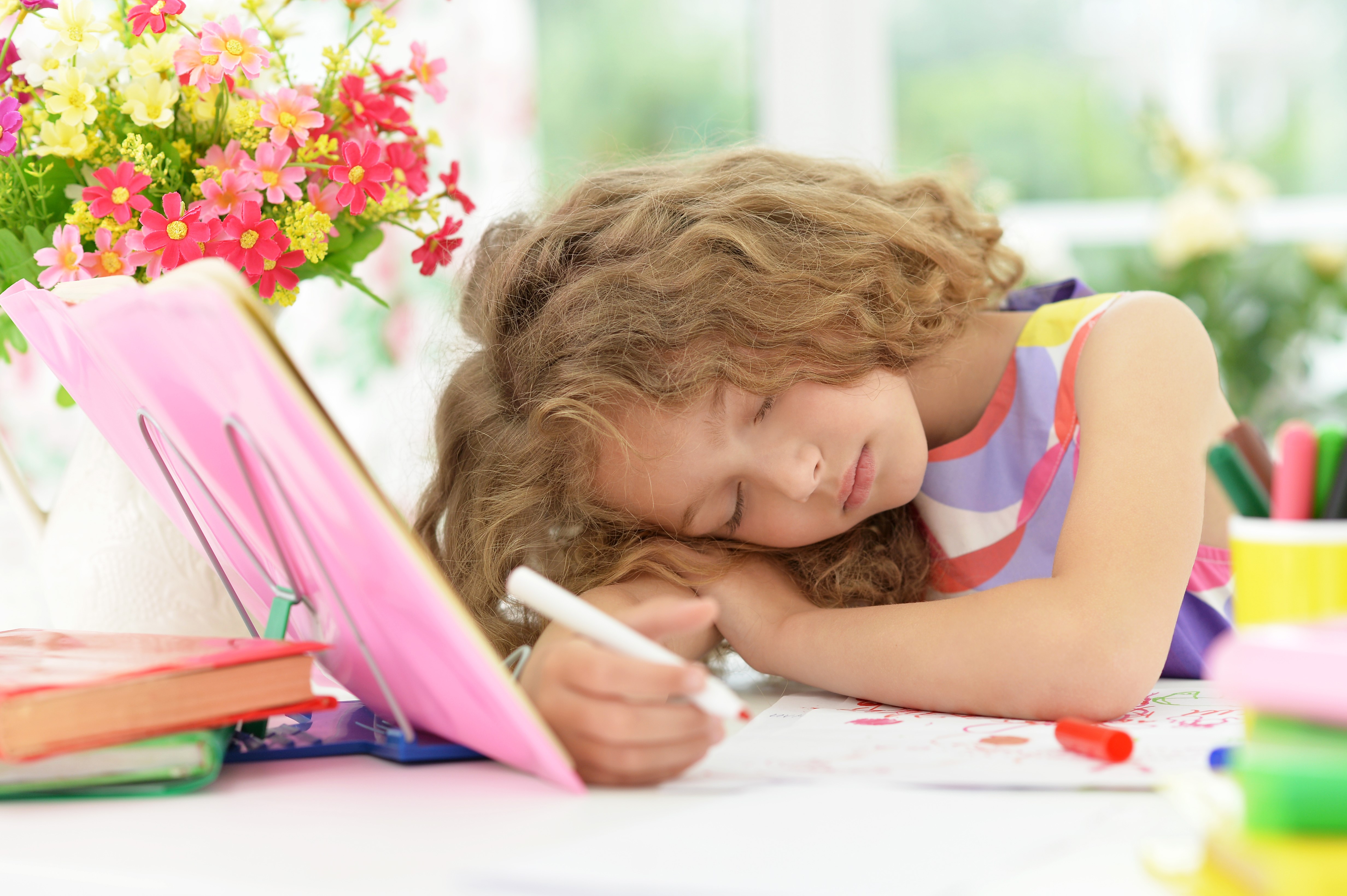 Little girl sleeping at desk with flowers HD Wallpaper