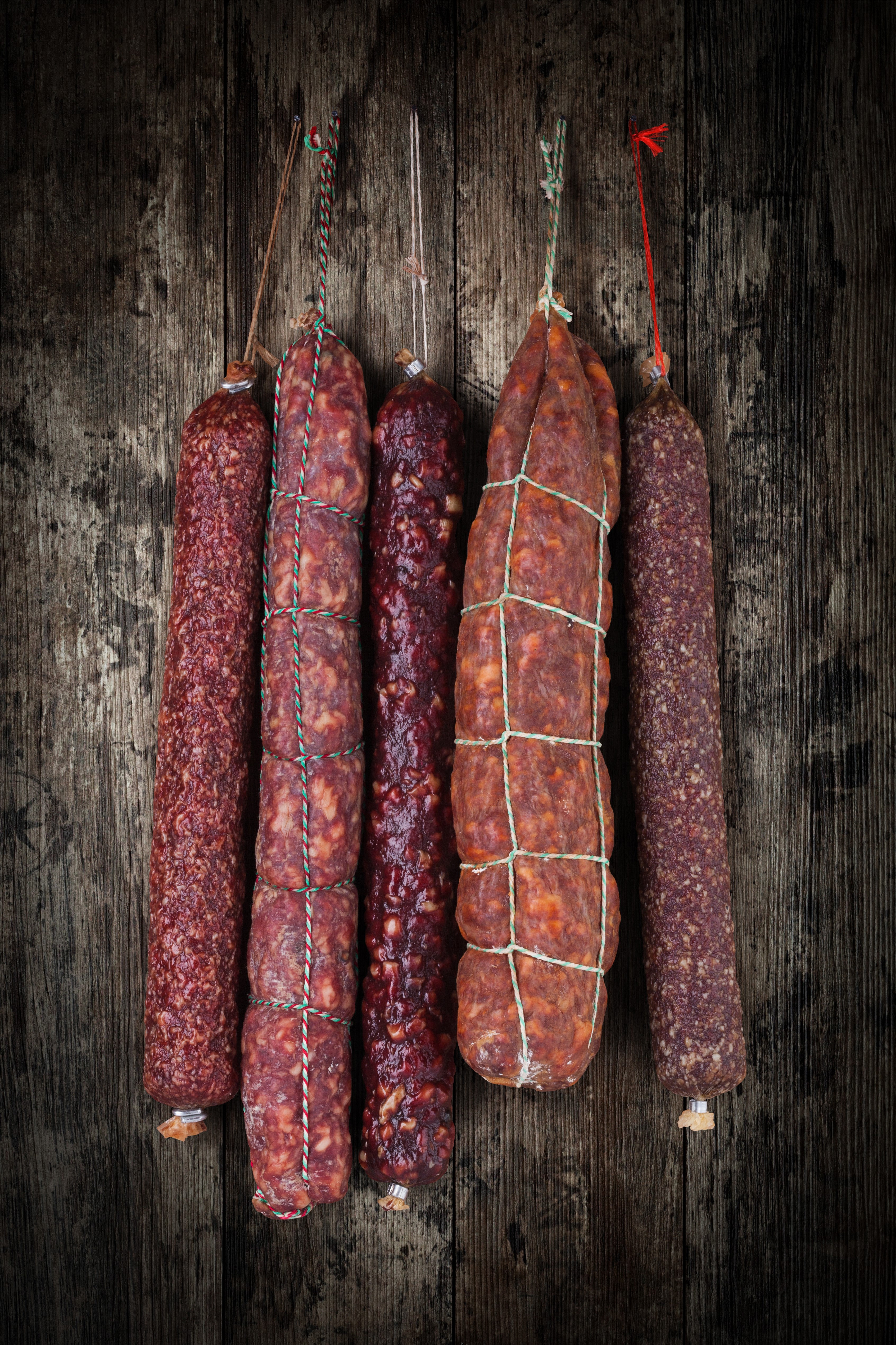 Five types of sausages hanging on a wooden background HD Phone Wallpaper