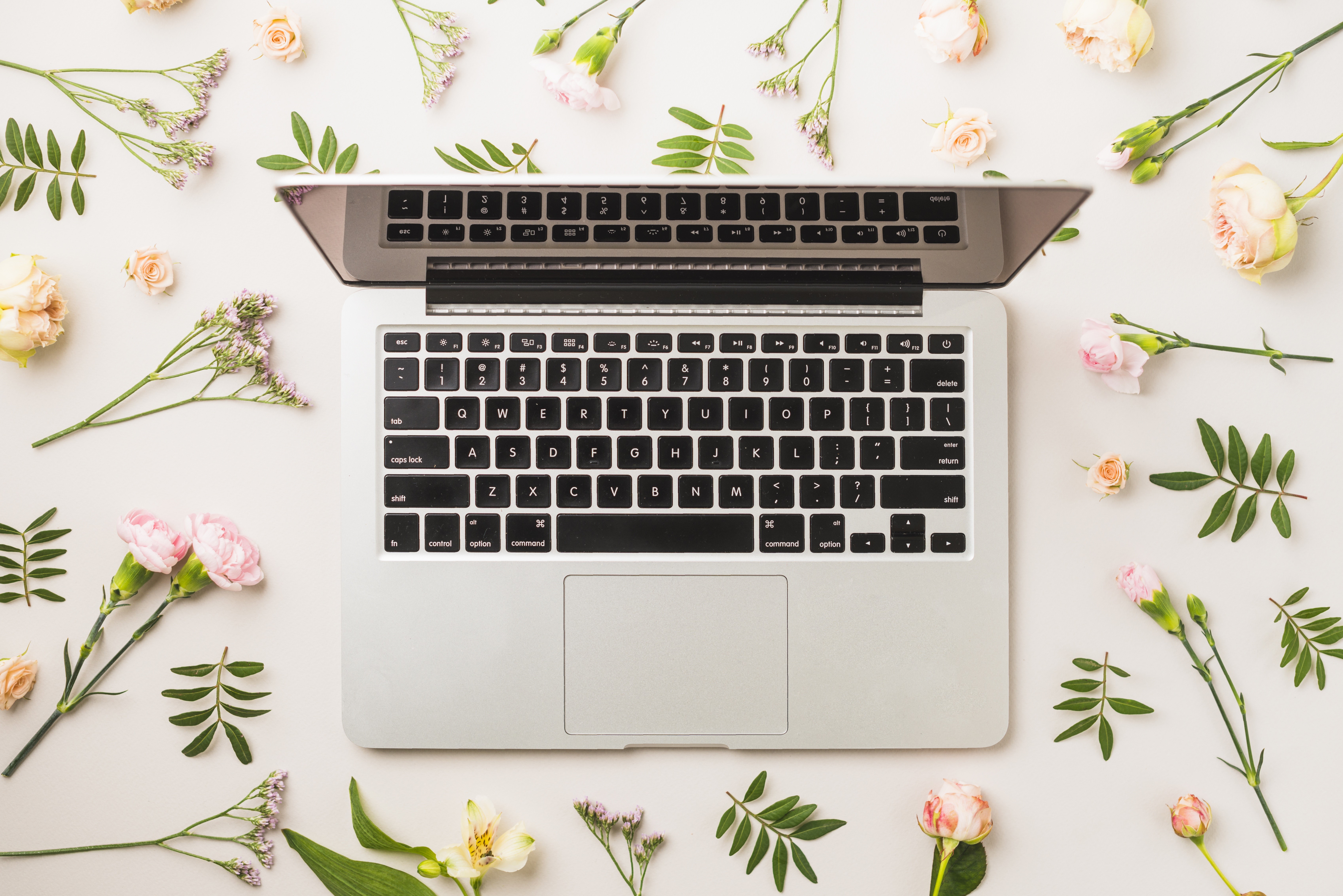 Laptop keyboard surrounded by flowers HD Wallpaper