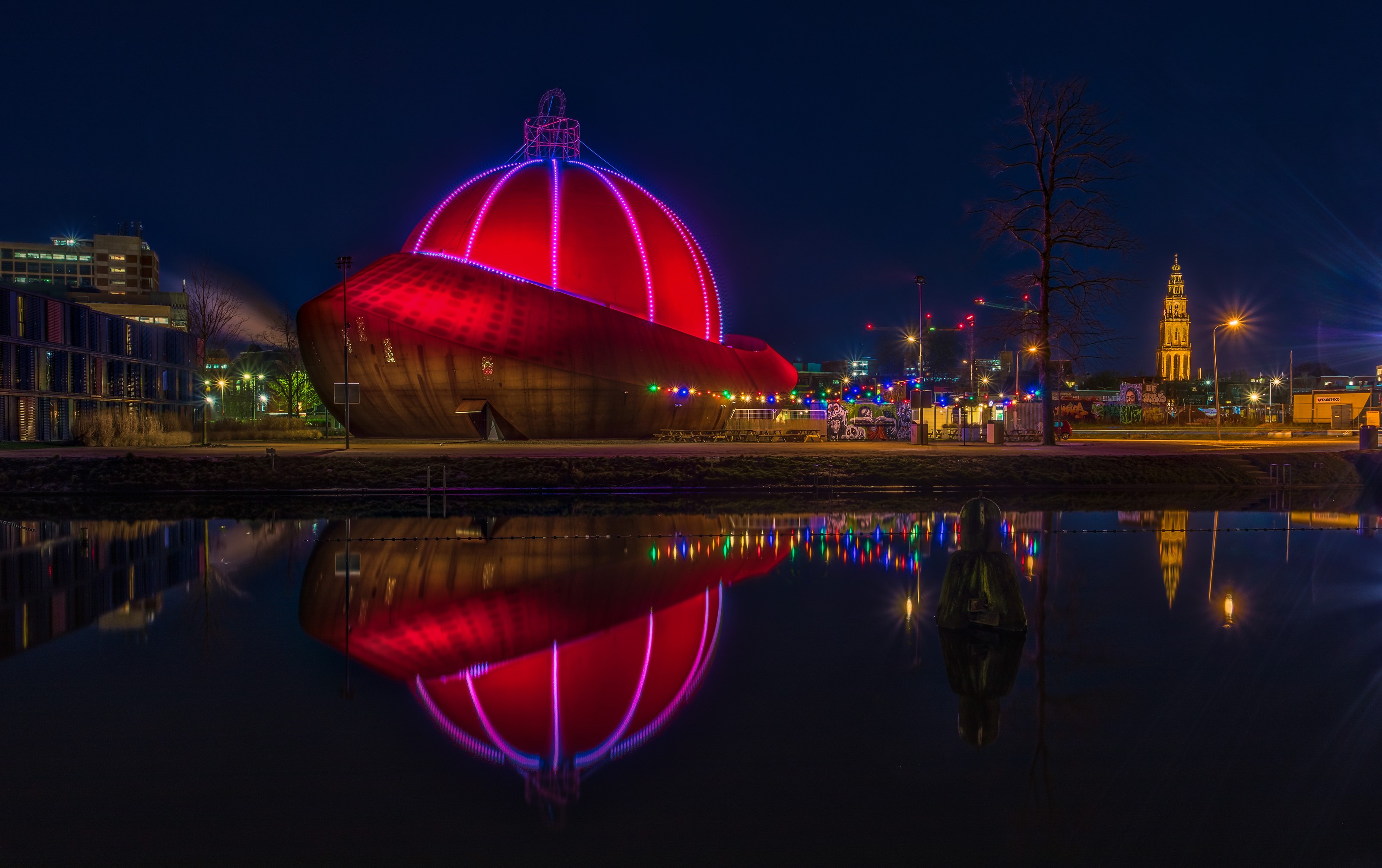 Giant Christmas ornament building reflected in water at night in Groningen, Netherlands HD Wallpaper