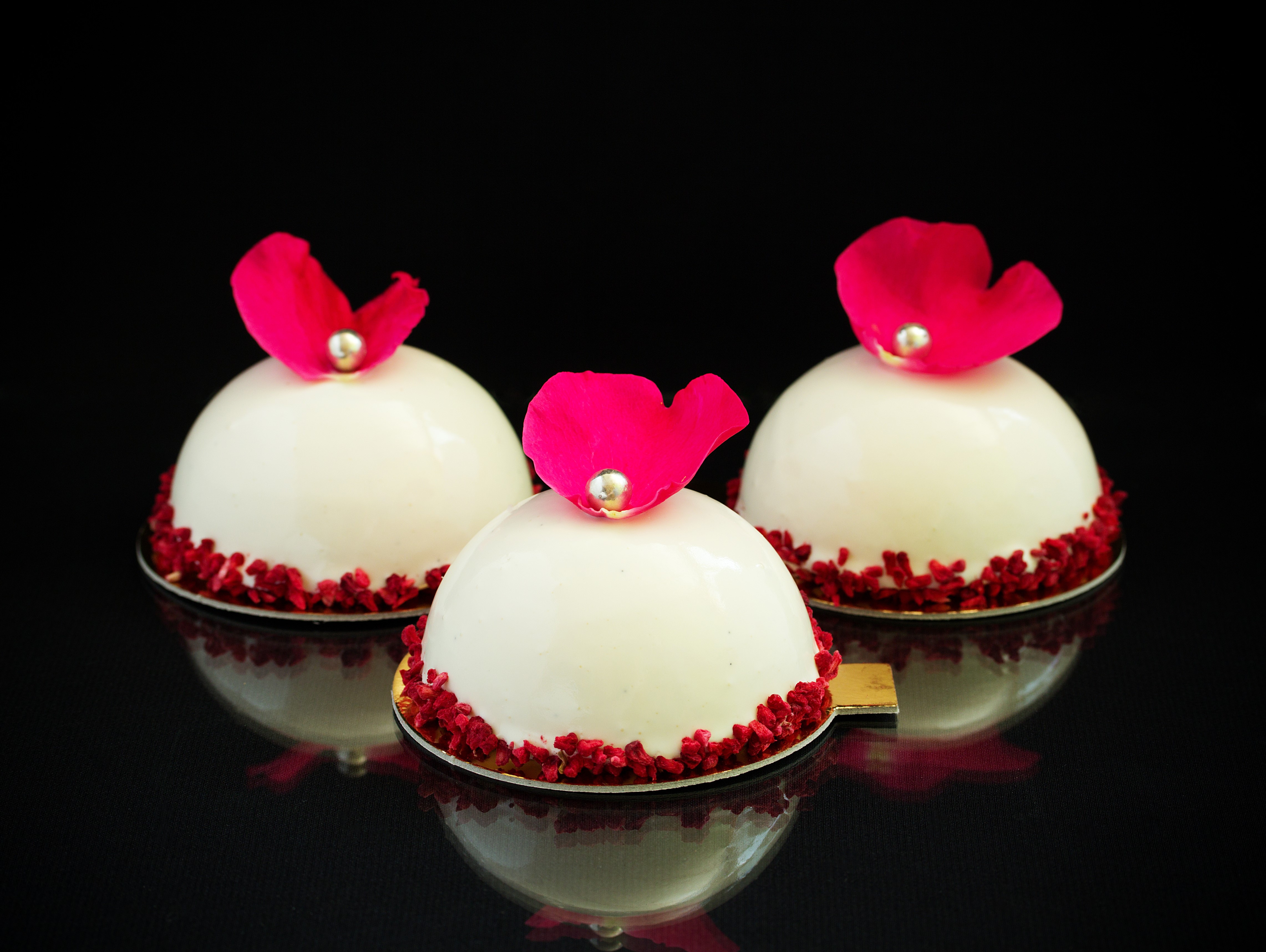 Three white dome cakes with pink petals and silver pearls HD Wallpaper