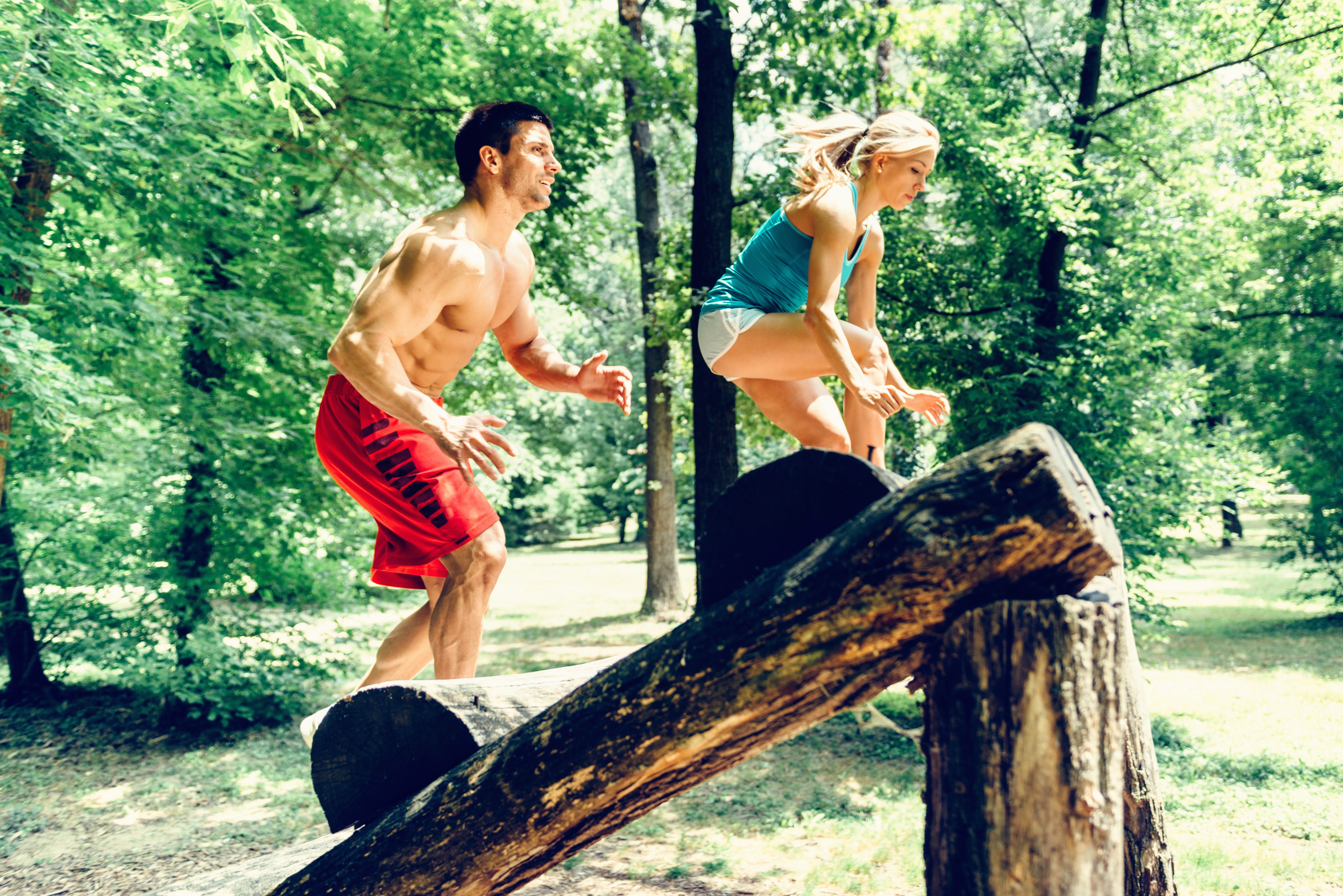 Man and woman doing fitness workout on logs HD Wallpaper