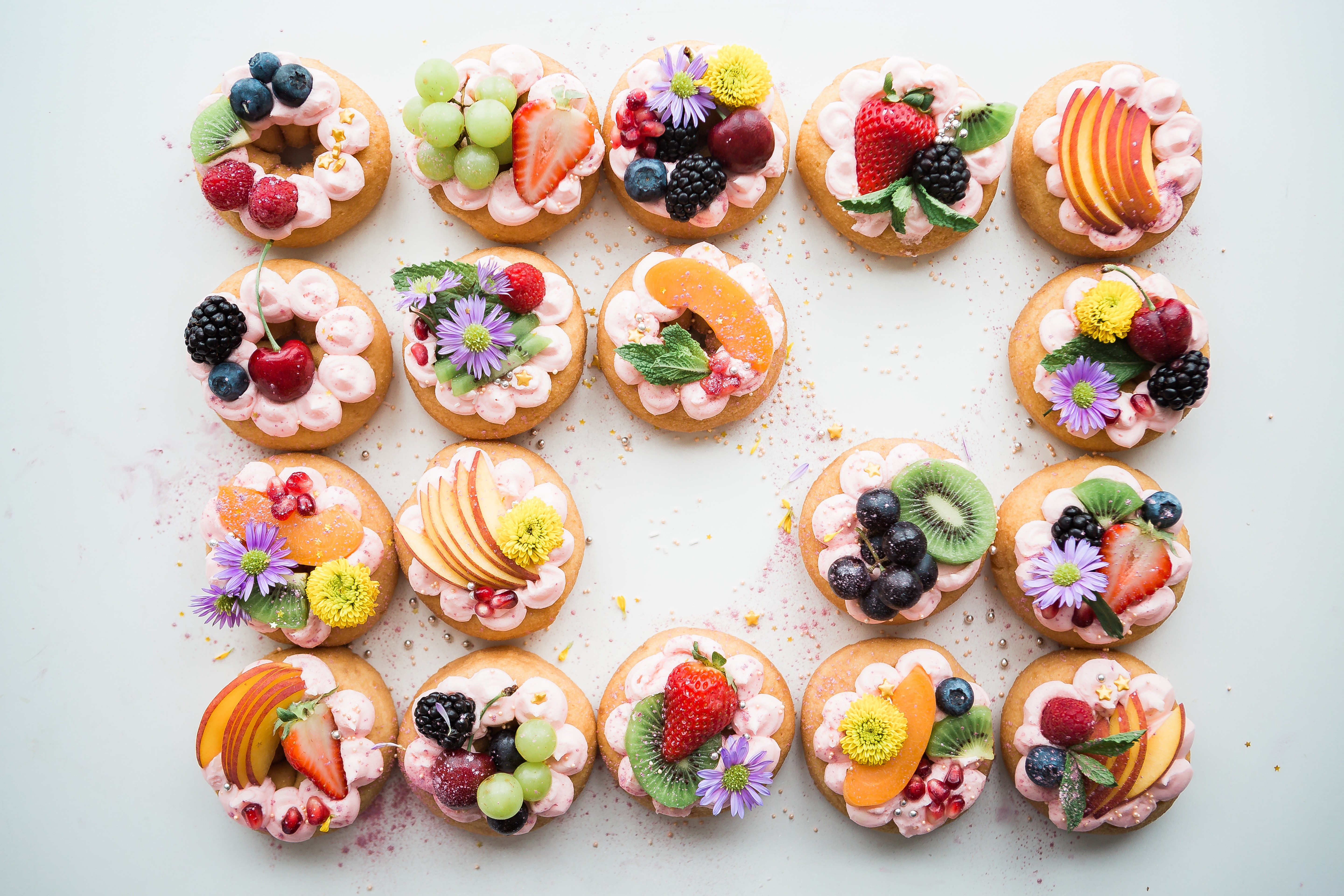Assortment of decorated donuts with fresh fruit HD Wallpaper
