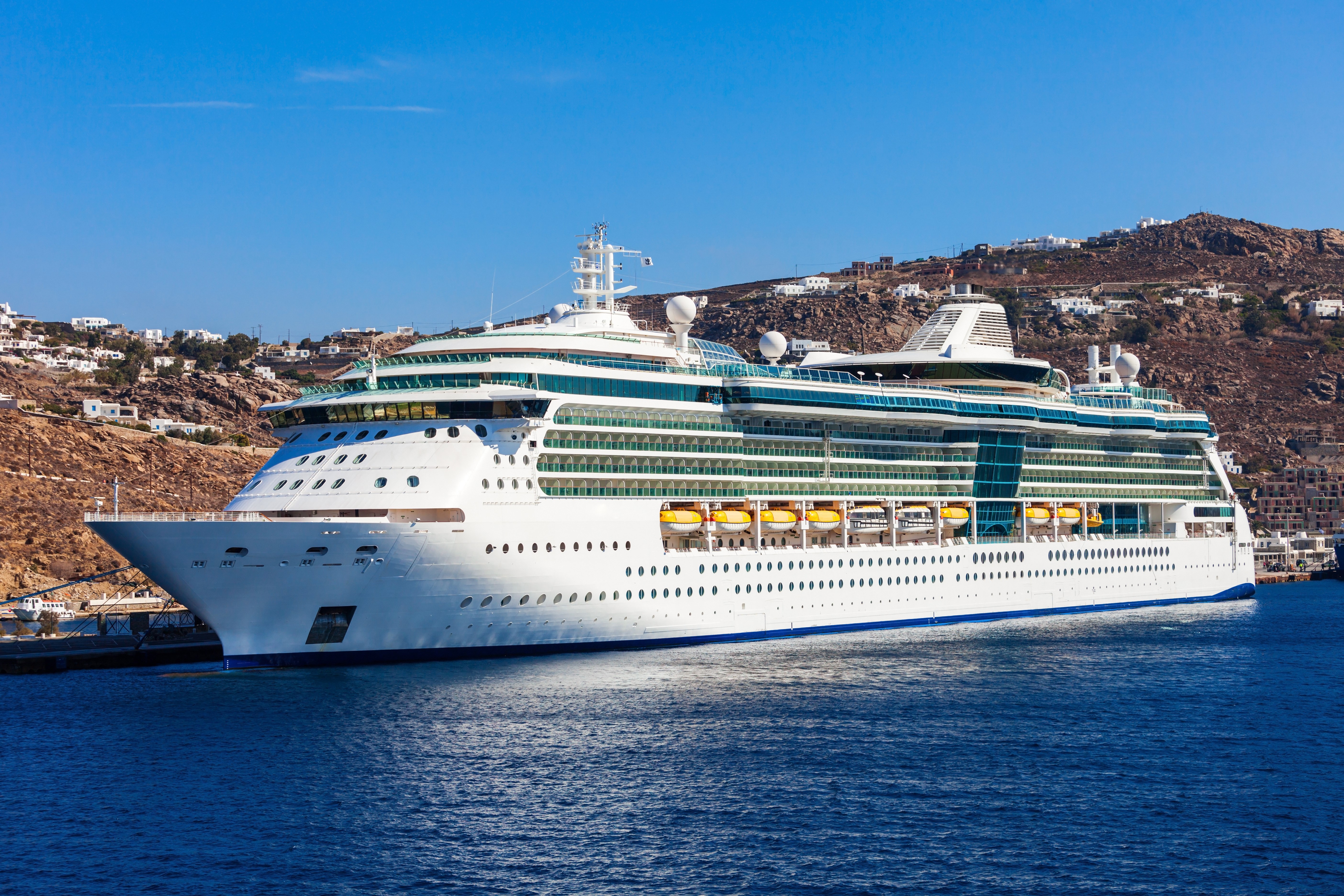 Cruise liner docked in a harbor with a town on a hill HD Wallpaper