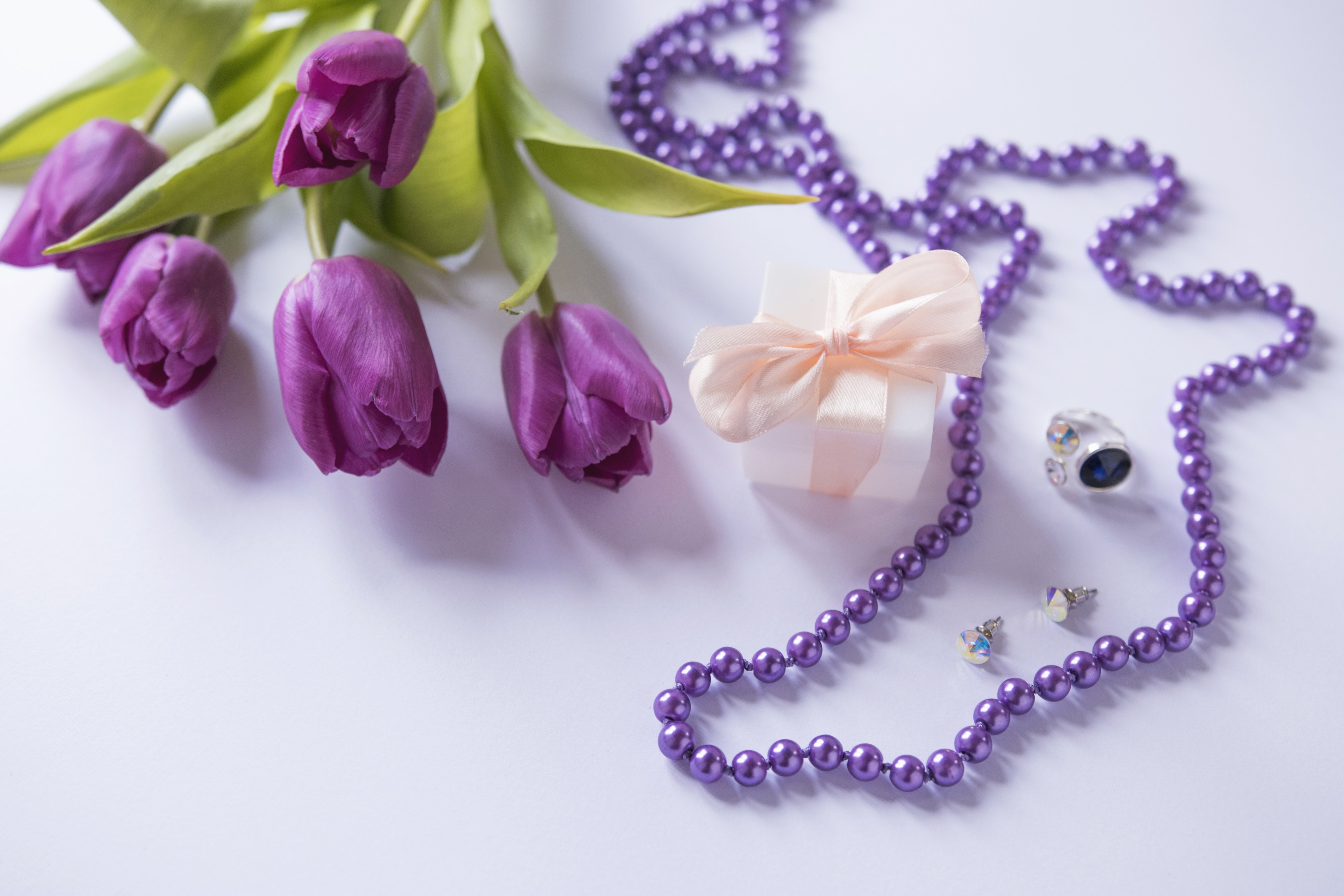 Purple tulips, gift box, and jewelry on a light background HD Wallpaper