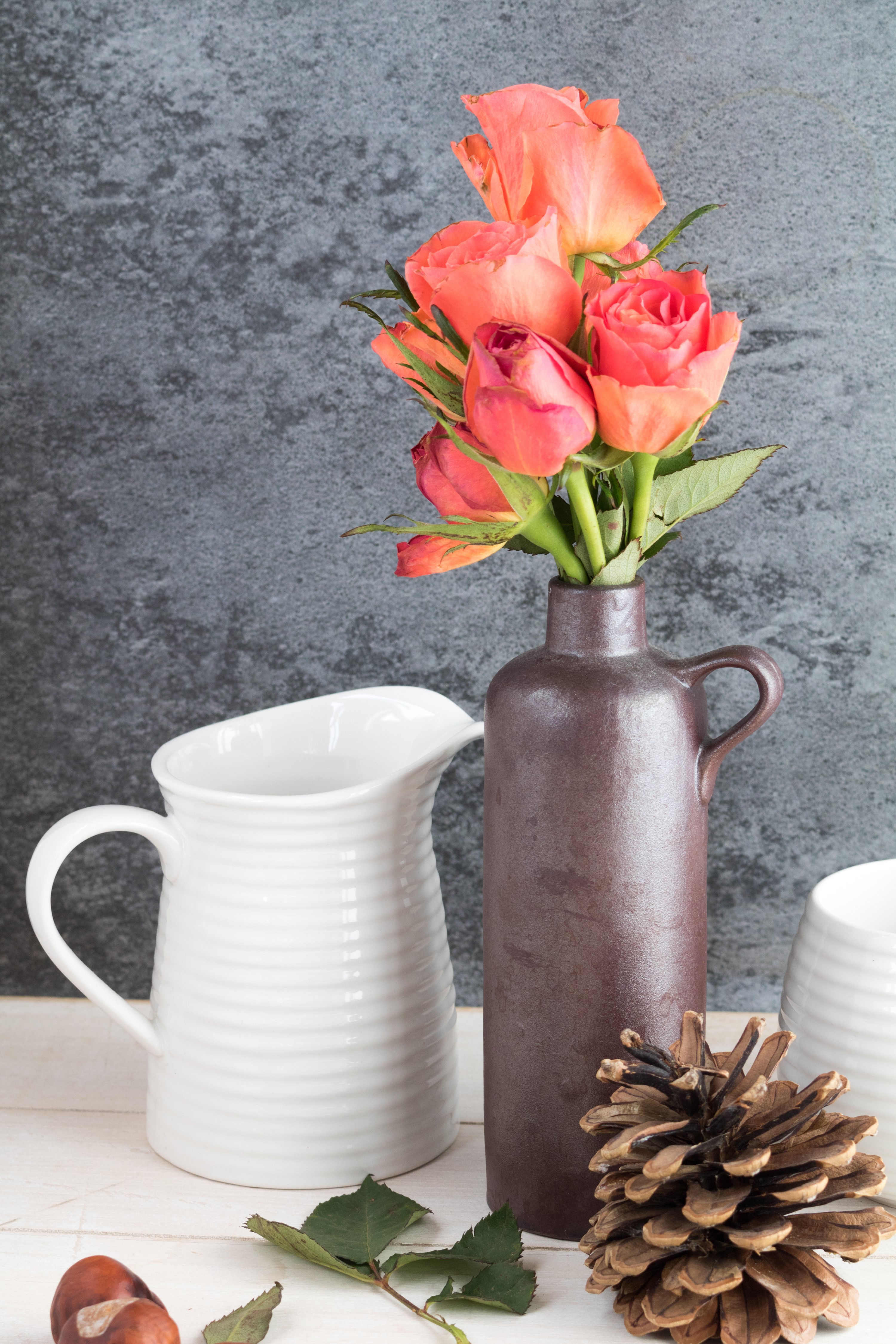 Still-life with coral roses in a vase and a pine cone HD Phone Wallpaper