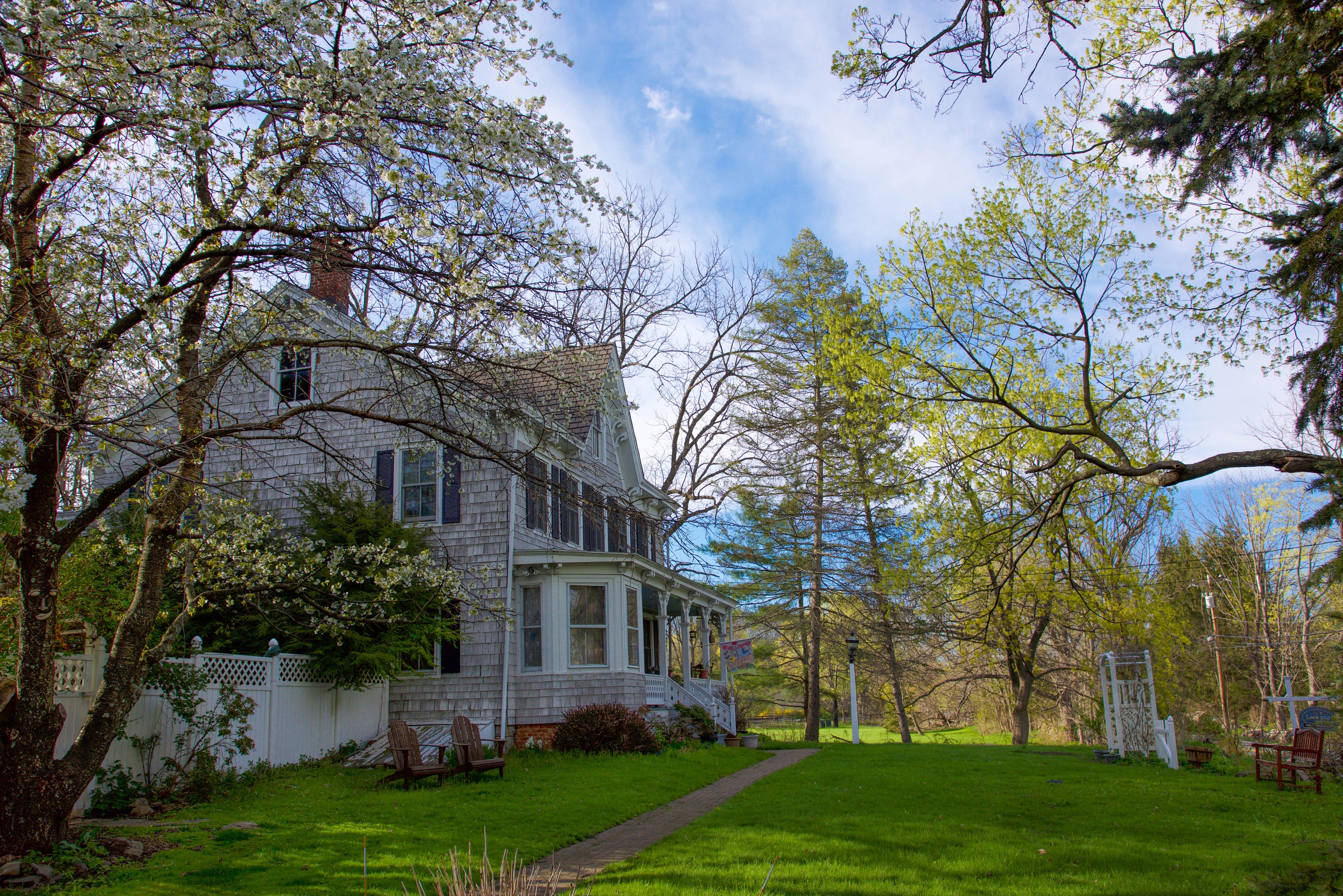 Victorian house with flowering trees and lawn HD Wallpaper