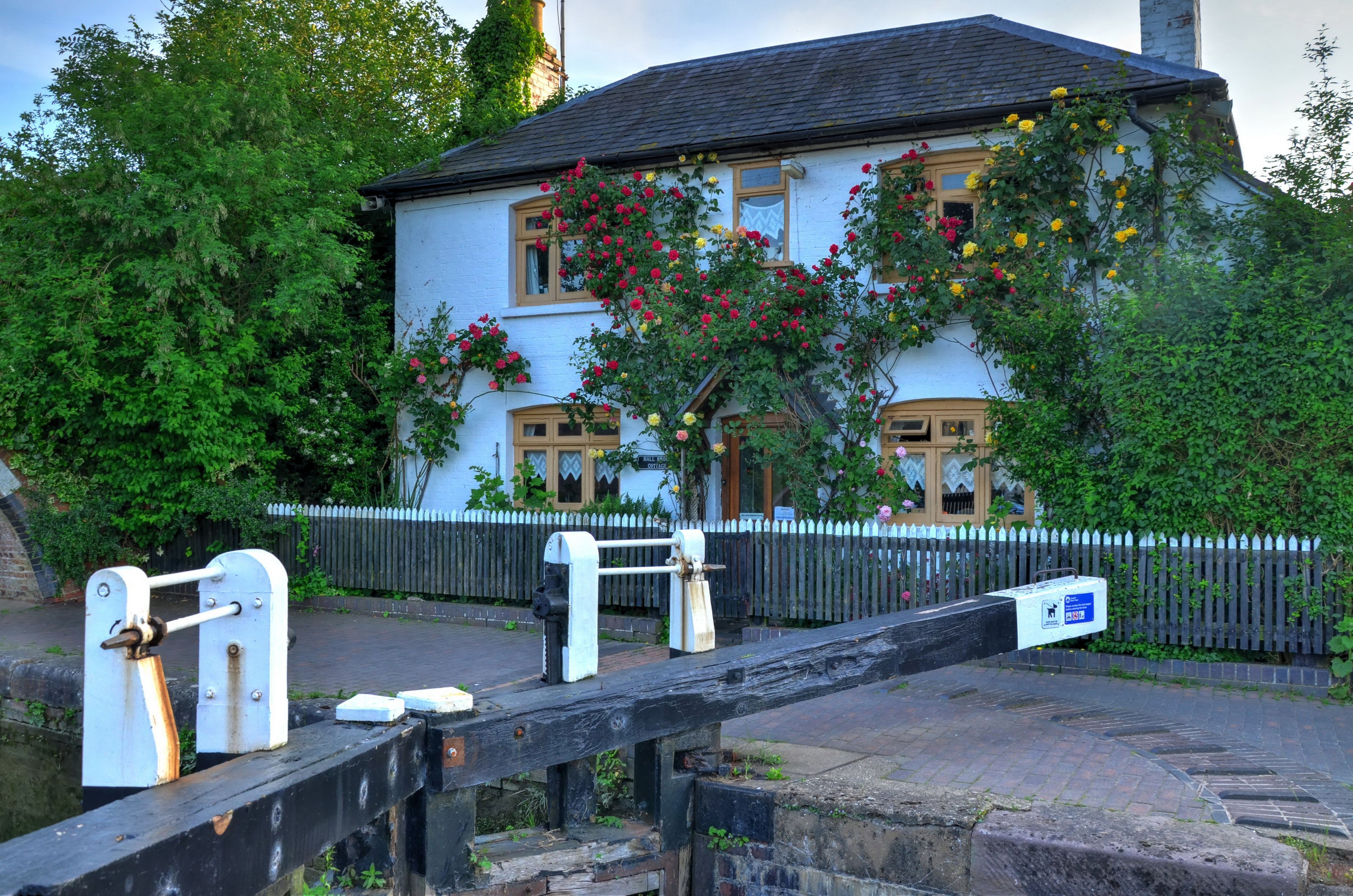 Canal lock house with climbing roses and wooden lock gate HD Wallpaper