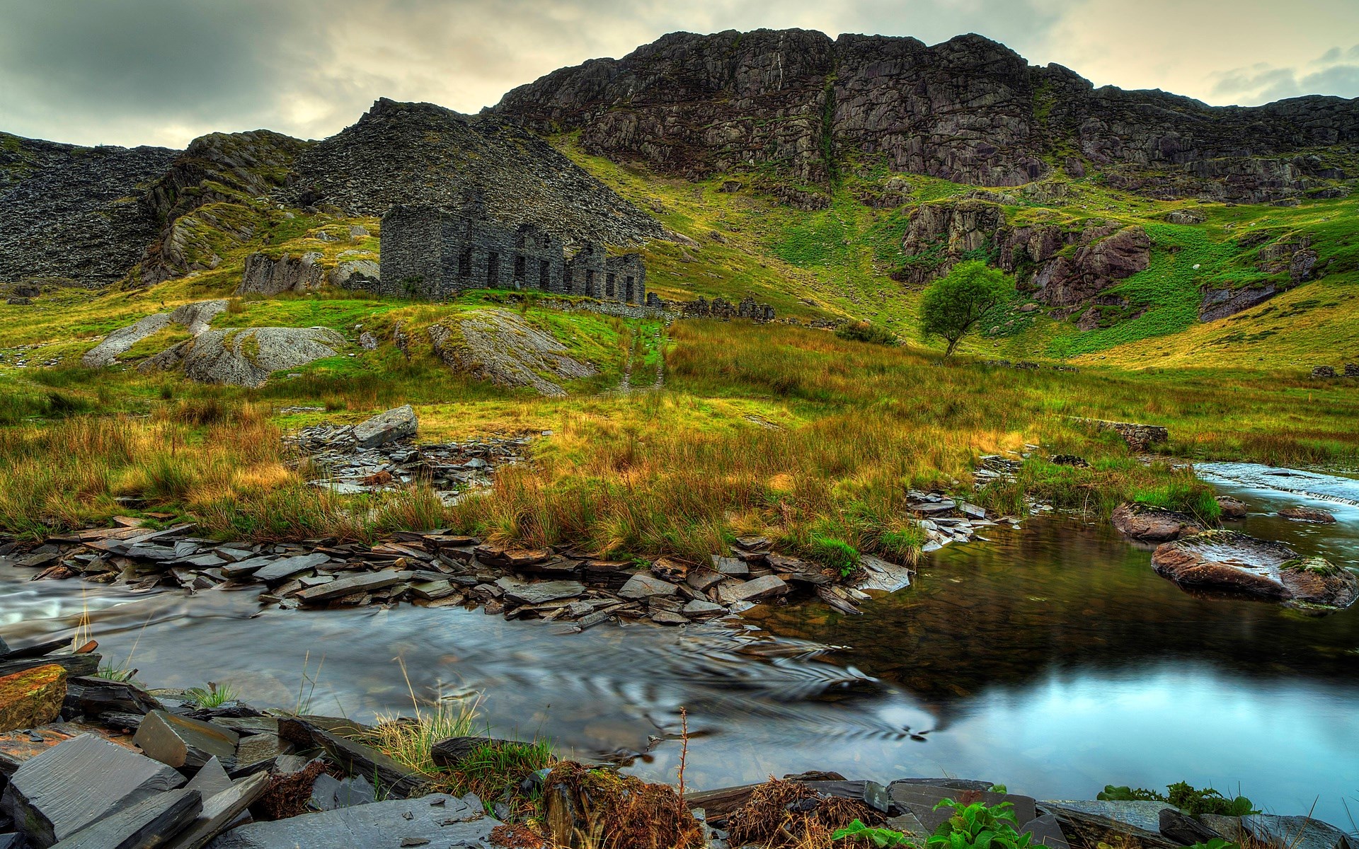 Abandoned stone building in a mountainous landscape with a stream HD Wallpaper