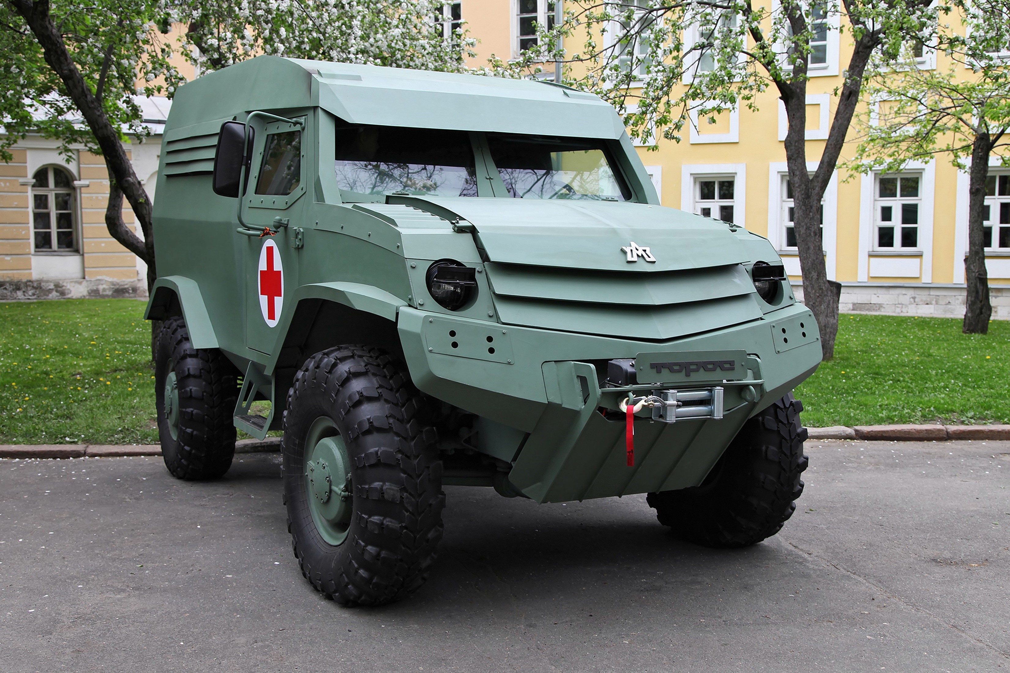 Green armored medical vehicle with red cross emblem HD Wallpaper