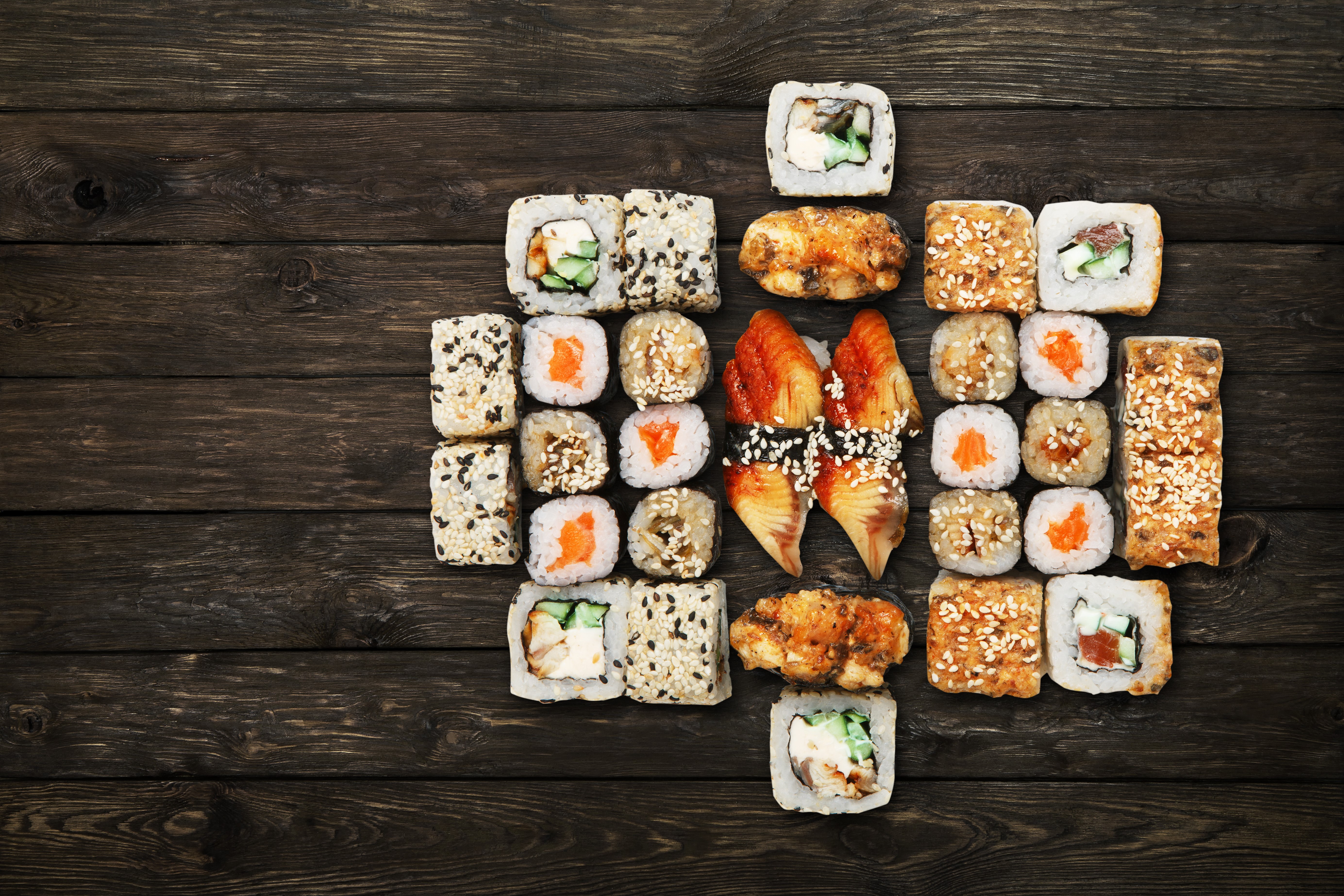 Sushi assortment on dark wood planks HD Wallpaper