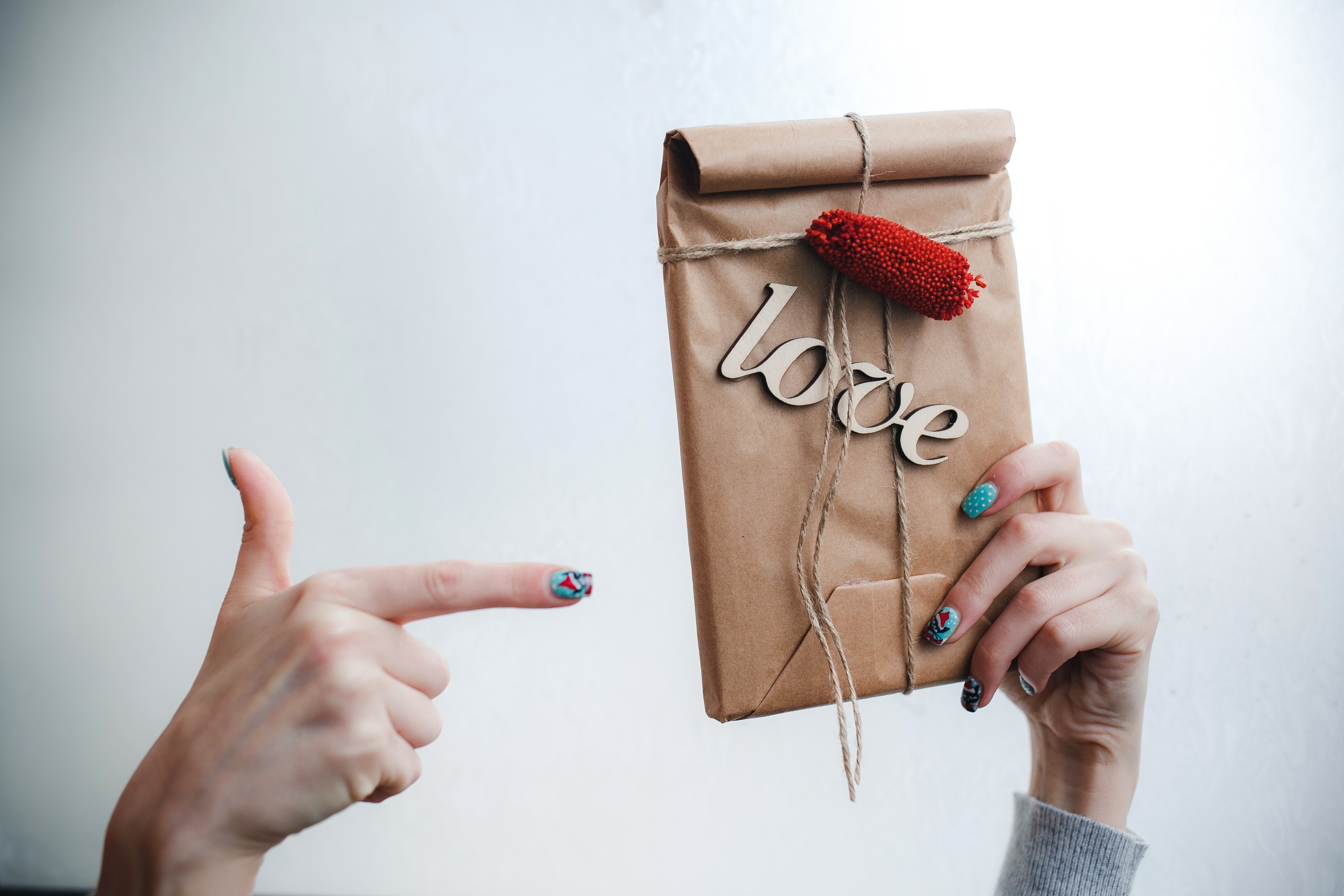 Hands holding a gift with the word 'love' HD Wallpaper