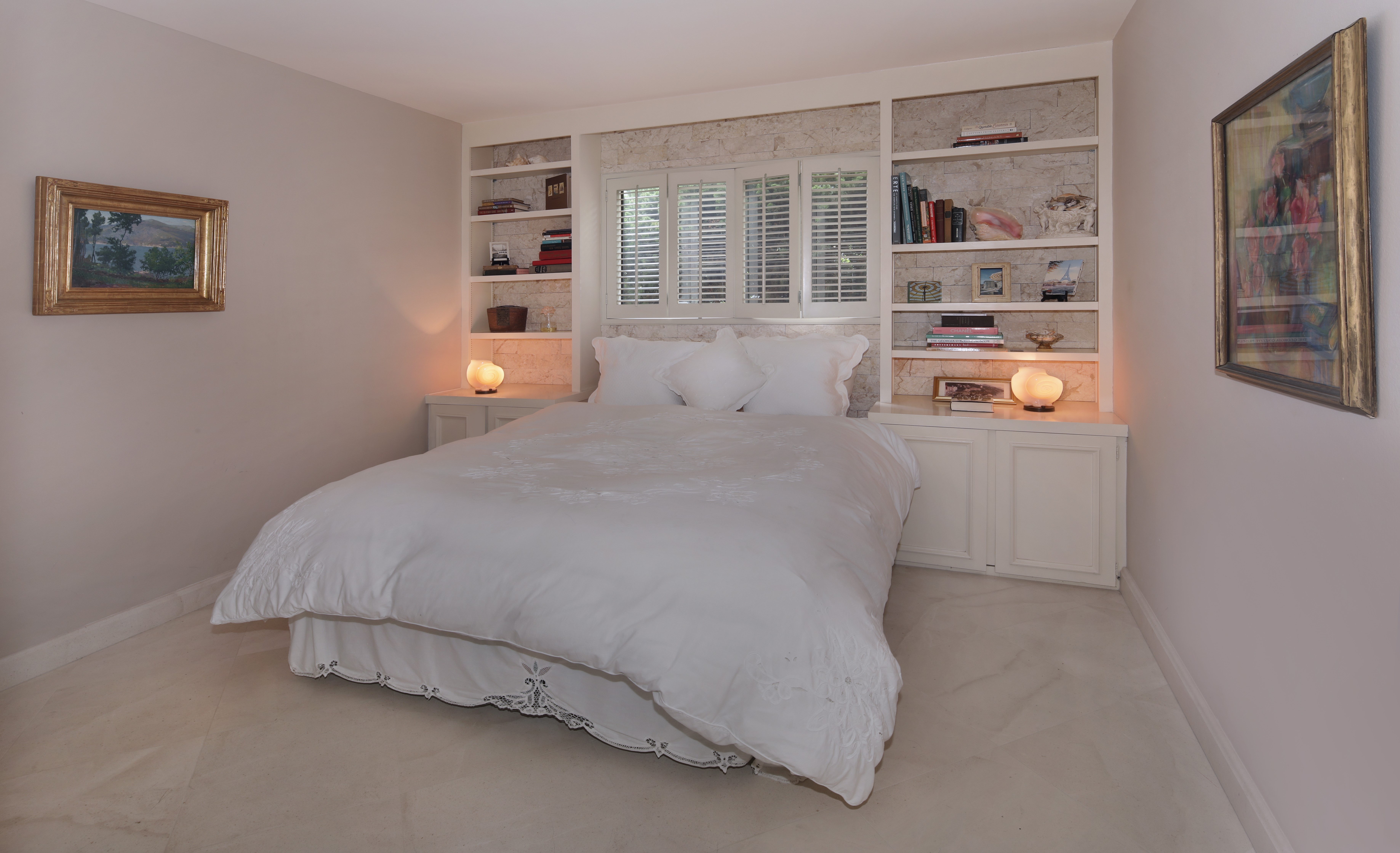 Bedroom with built-in bookshelves and artwork HD Wallpaper