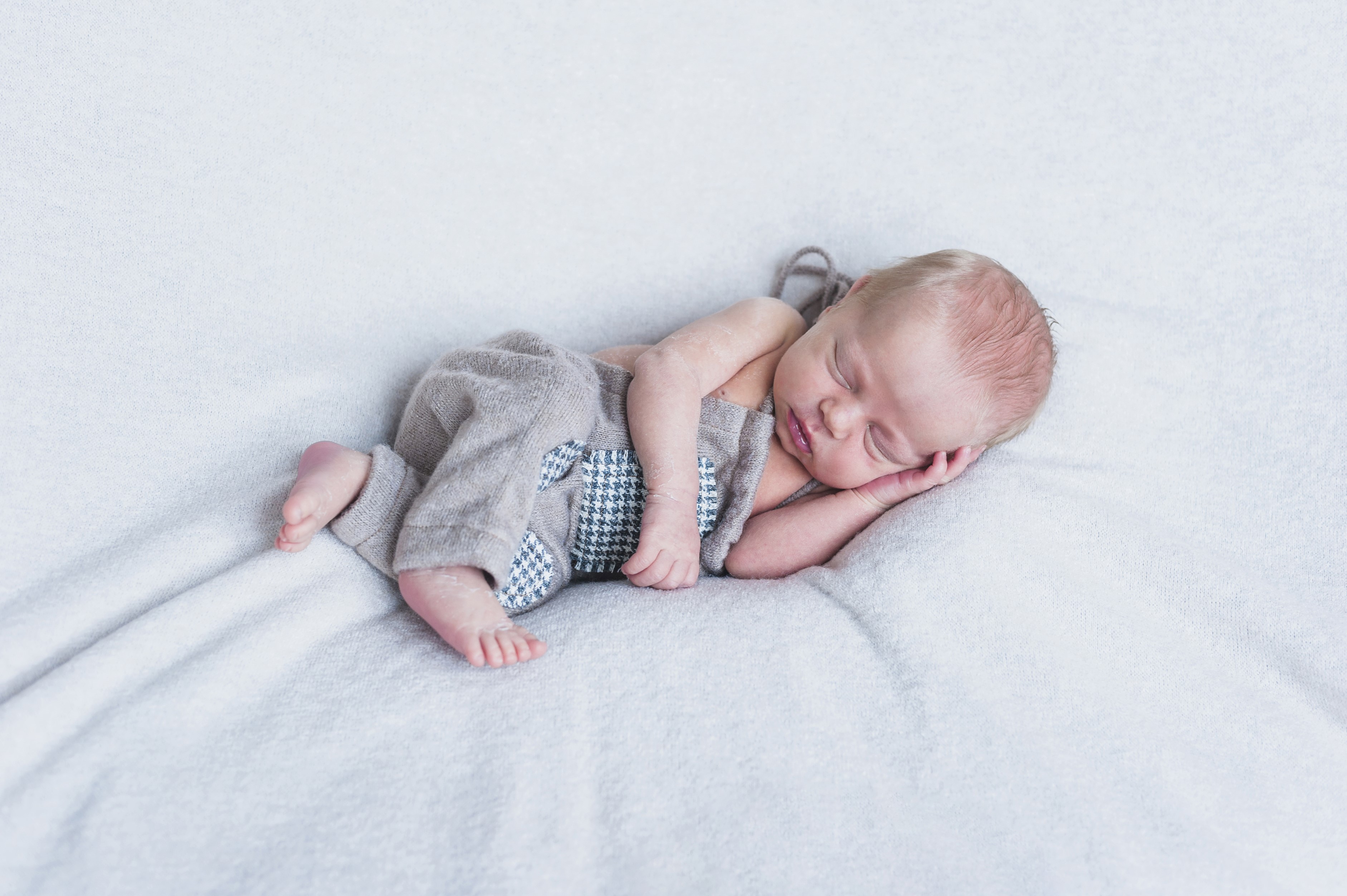 Newborn baby sleeping on a white blanket HD Wallpaper
