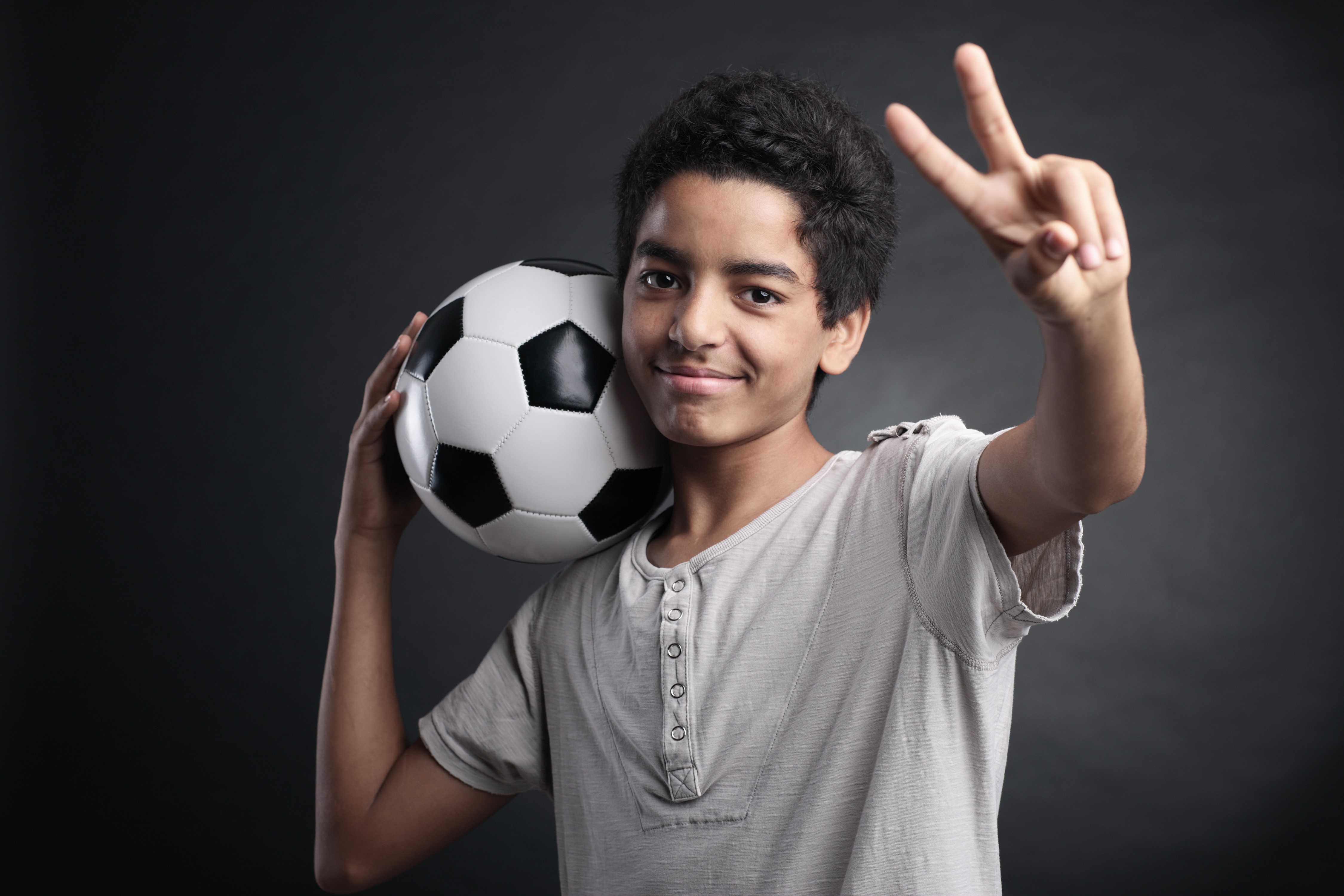 Boy with soccer ball making peace sign HD Wallpaper