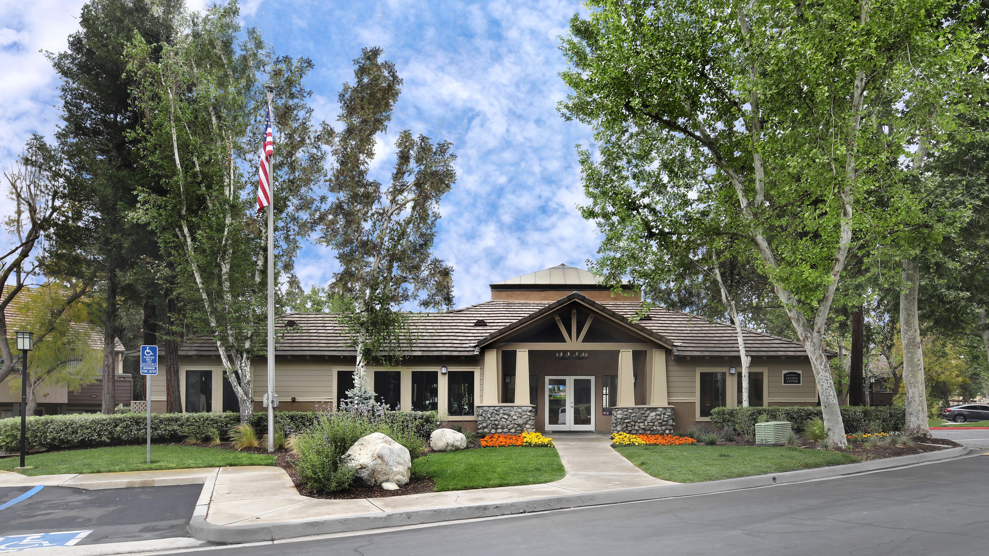 Apartment building entrance with American flag and trees HD Wallpaper