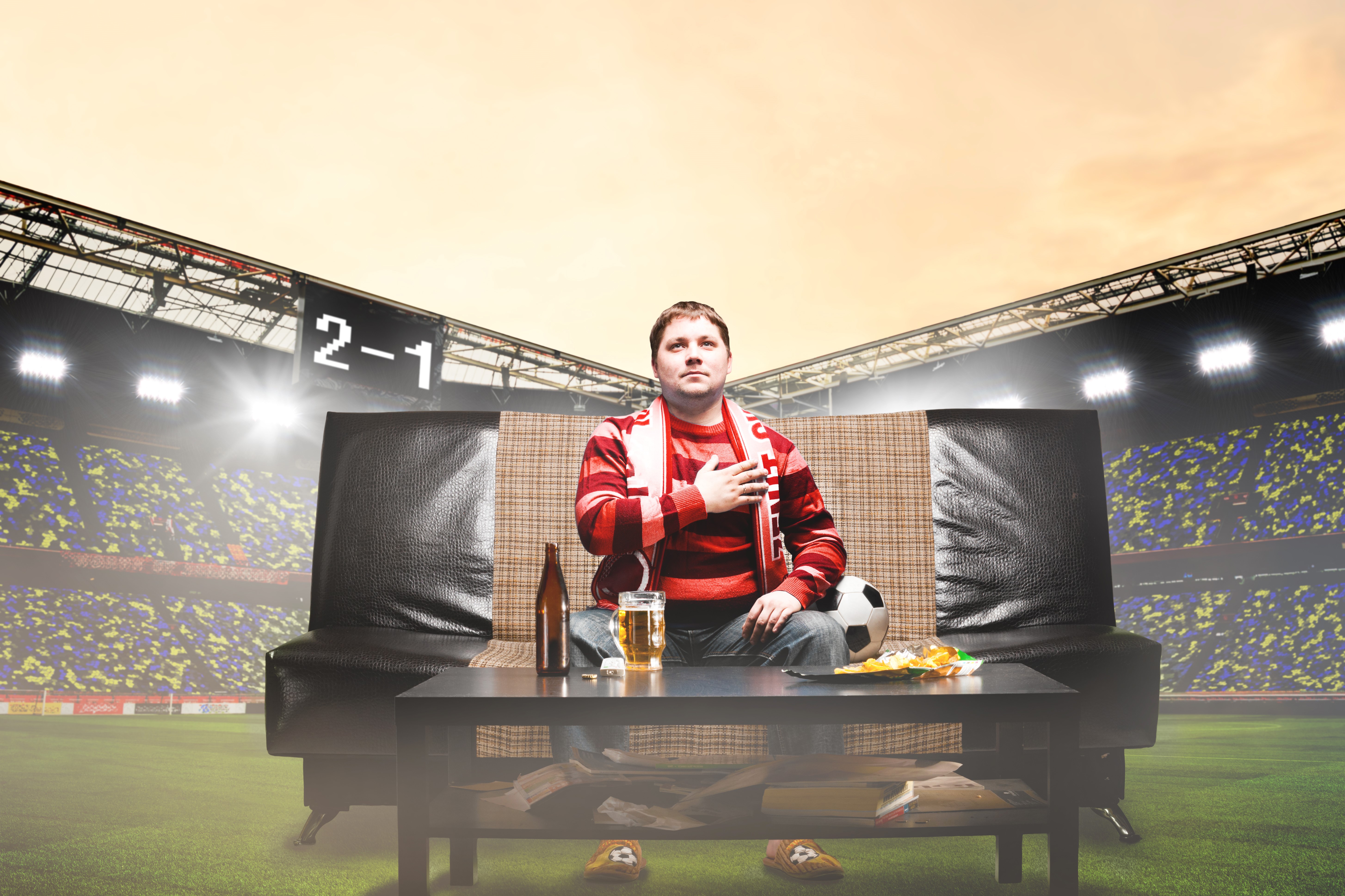 Man watching football game on sofa in stadium HD Wallpaper
