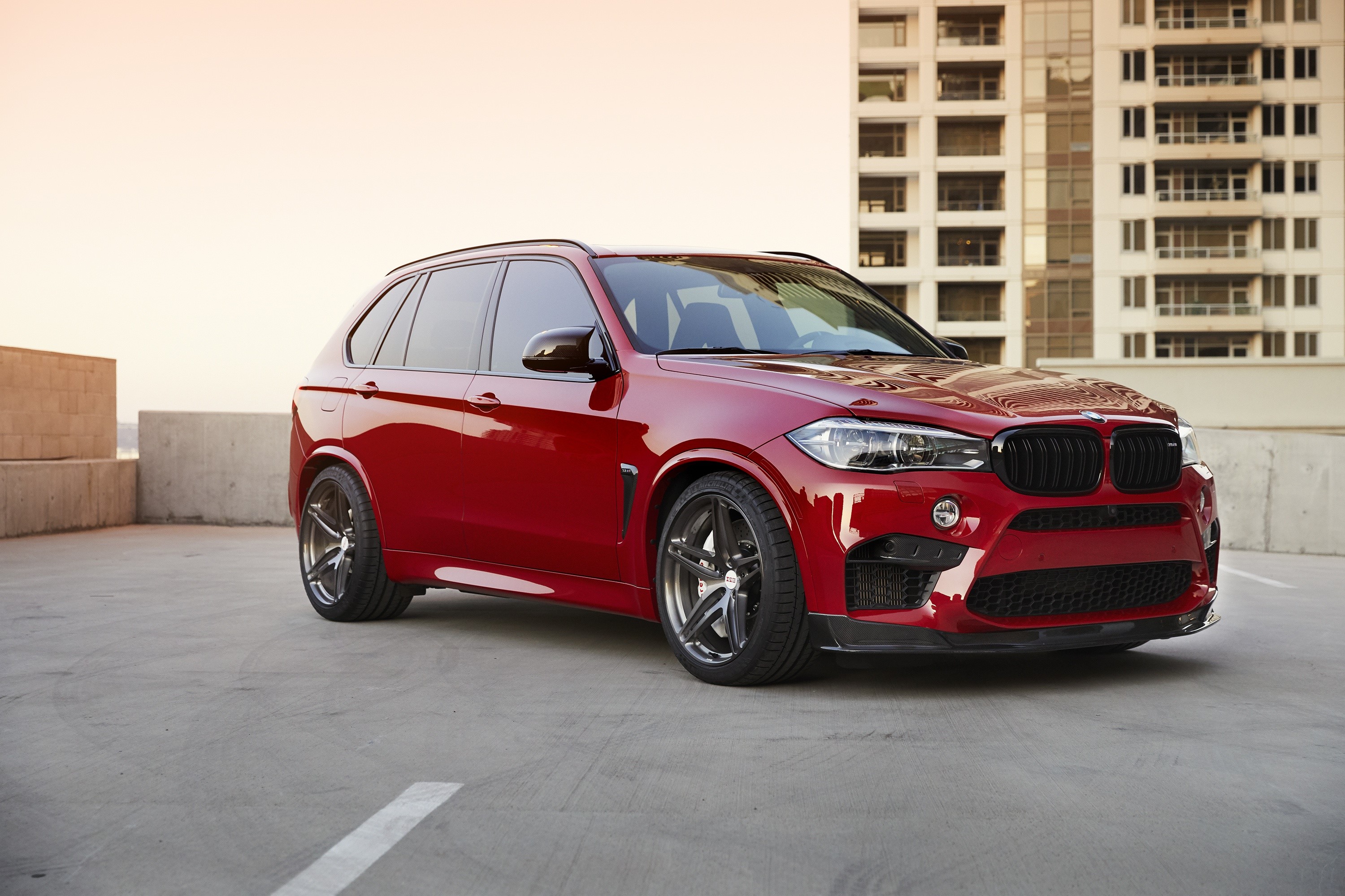 Red BMW X5M F85 parked in urban setting HD Wallpaper