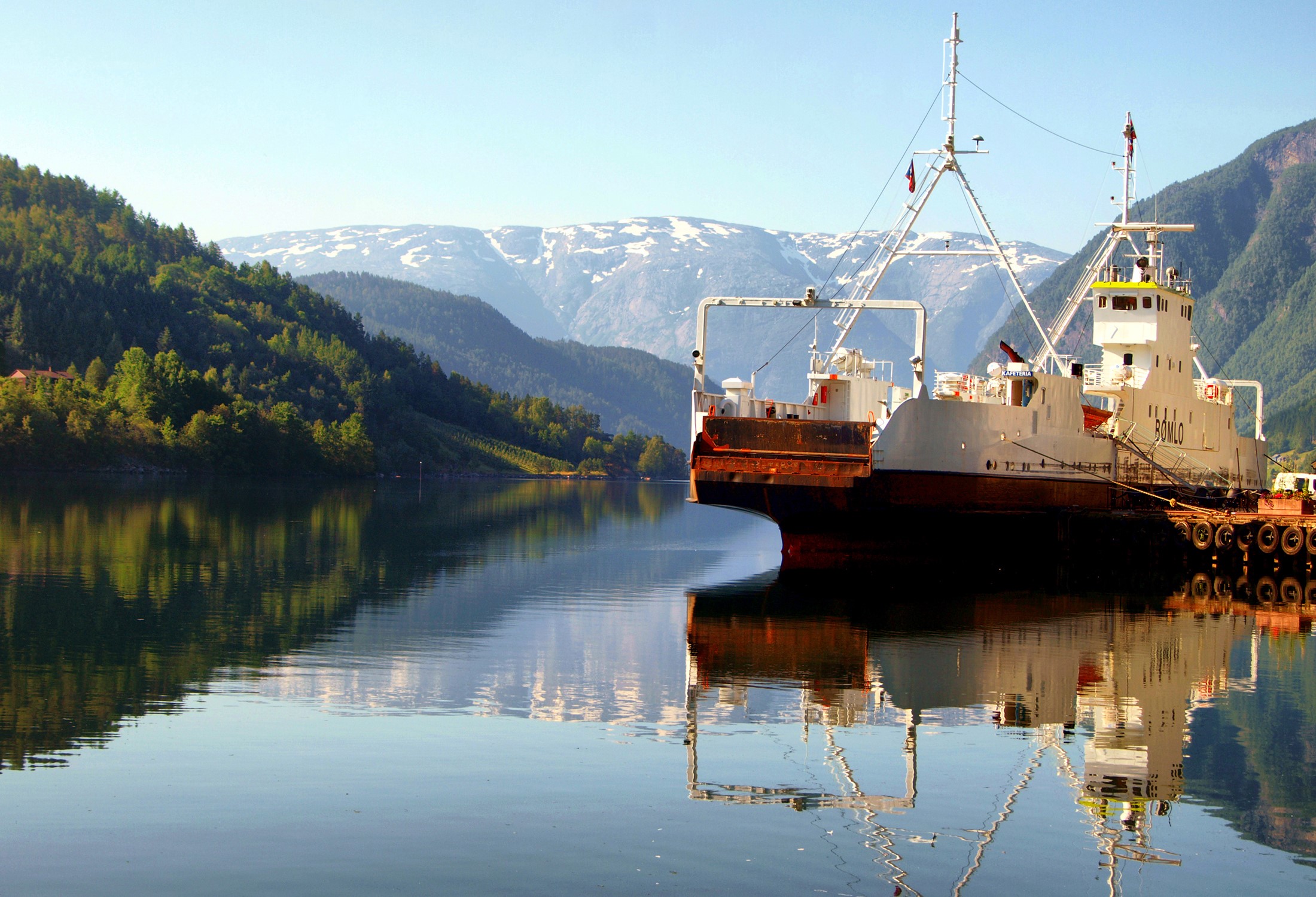 Ship docked in a Norwegian fjord with mountains HD Wallpaper