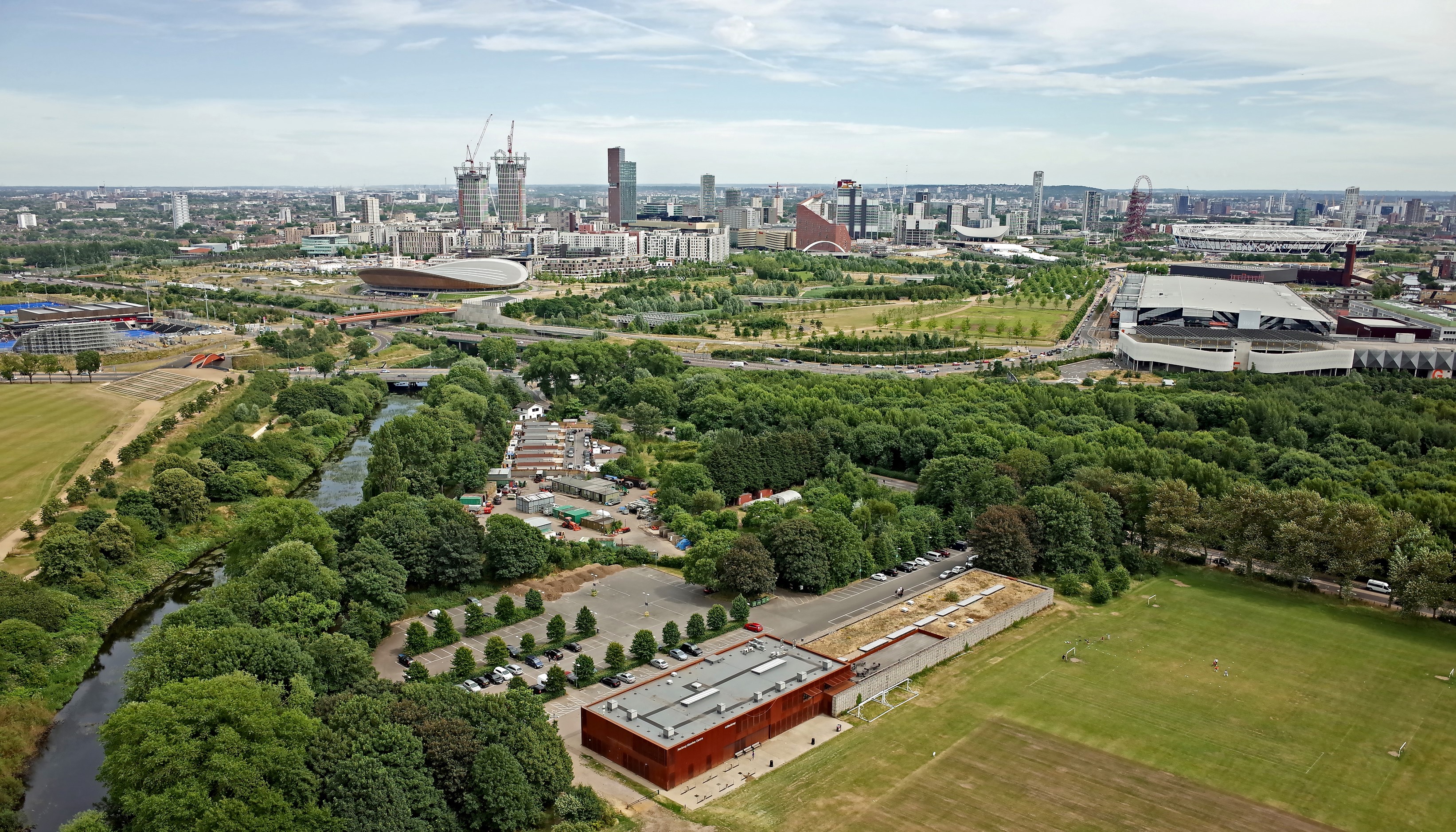 Aerial view of London Olympic Park with river and cityscape HD Wallpaper