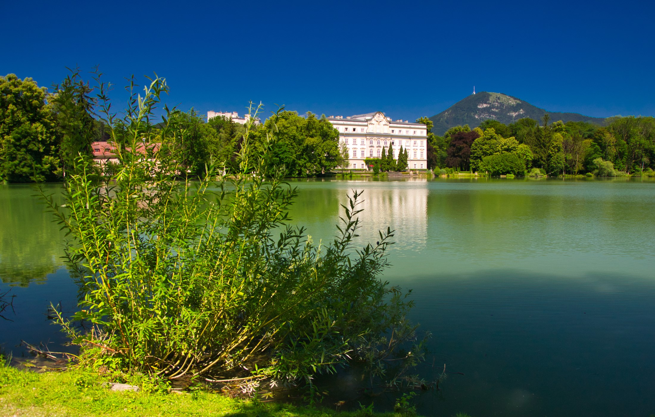 Schloss Leopoldskron lake with trees and mountains in Salzburg, Austria HD Wallpaper