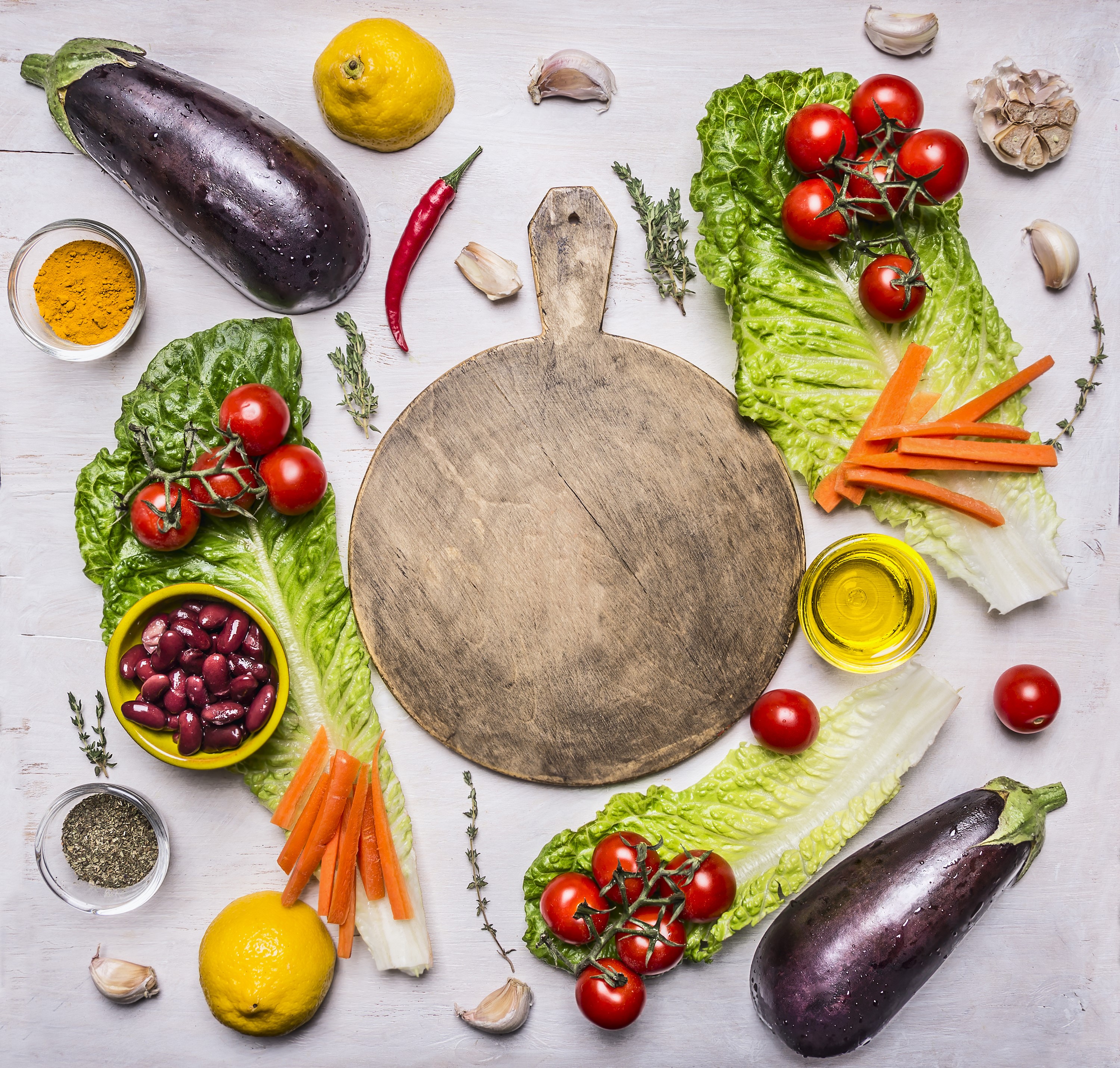Vegetables and ingredients arranged around a cutting board HD Wallpaper
