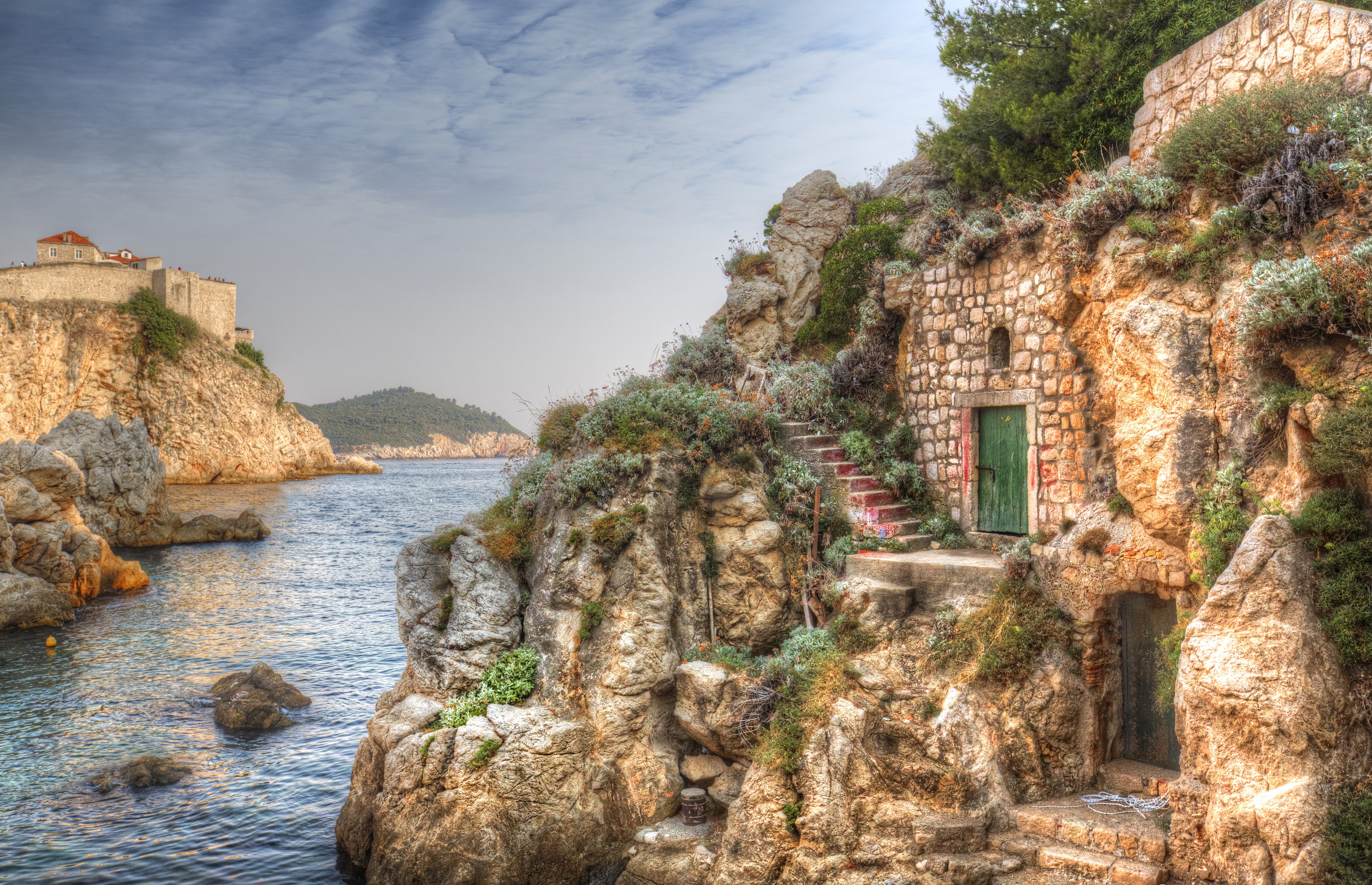 Stone houses on a rocky cliffside by the sea in Dubrovnik, Croatia HD Wallpaper