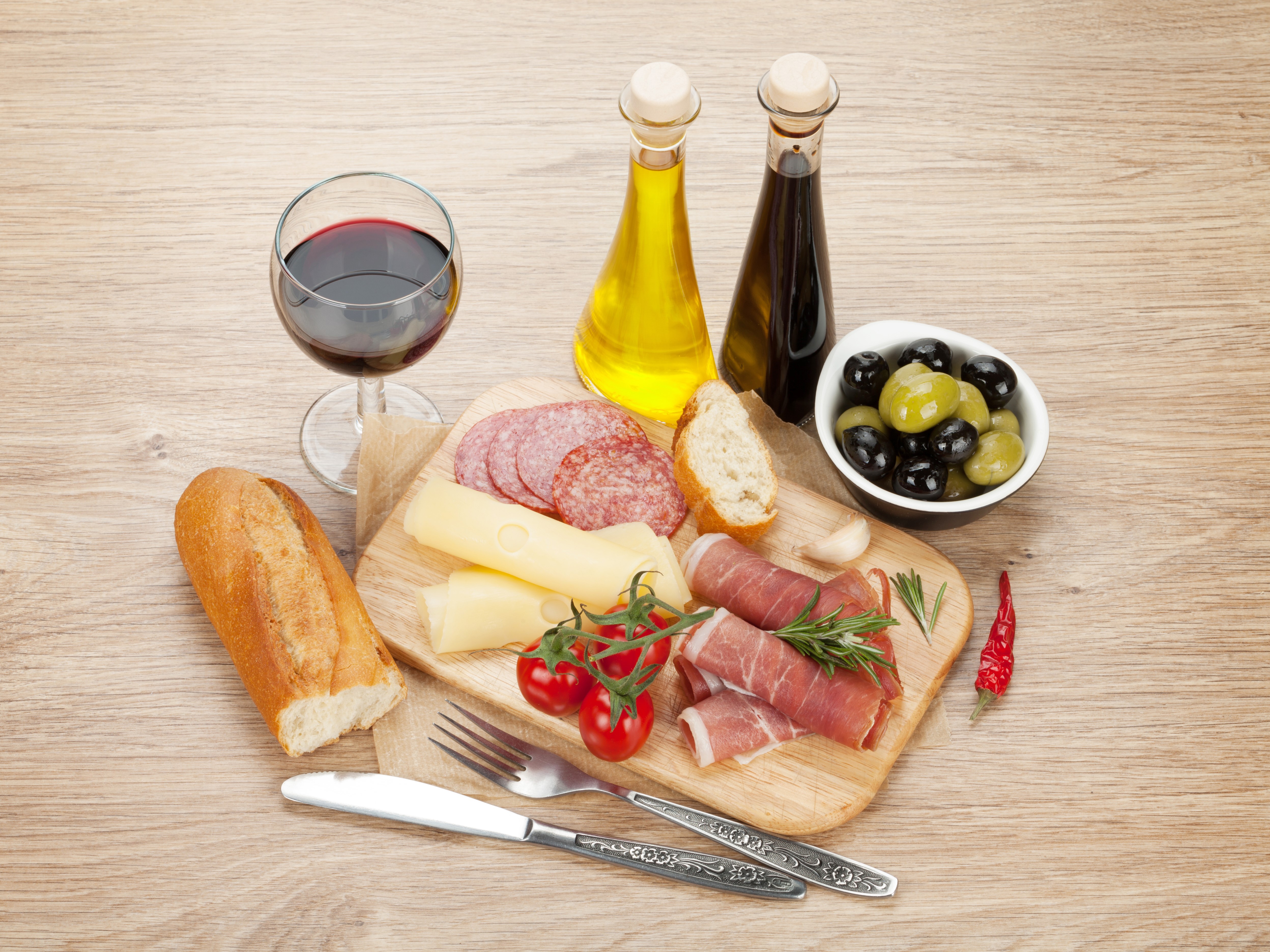 Charcuterie board with wine, cheese, ham, sausage, olives, and bread HD Wallpaper