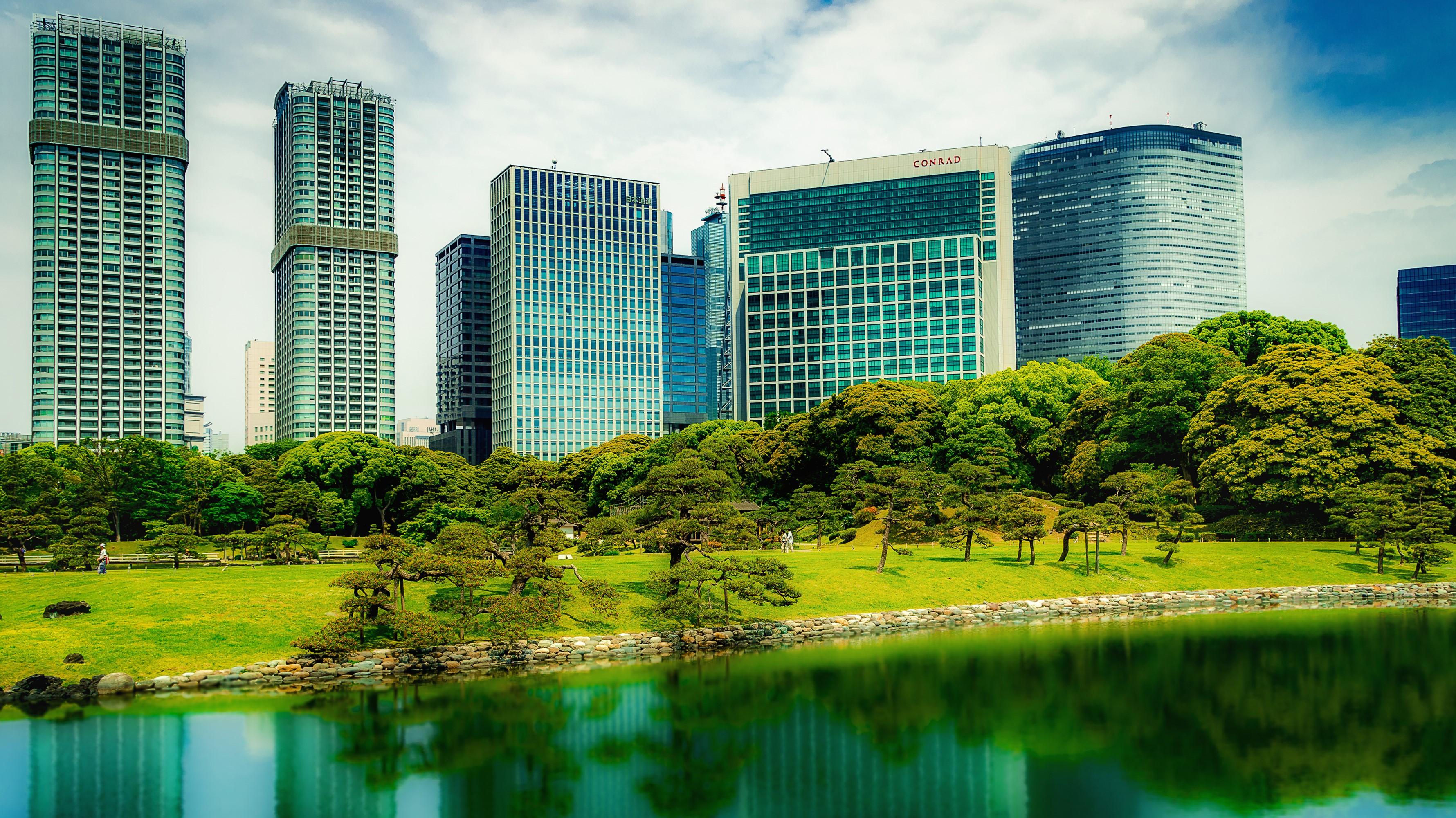 Tokyo skyscrapers and a Japanese garden with a pond HD Wallpaper