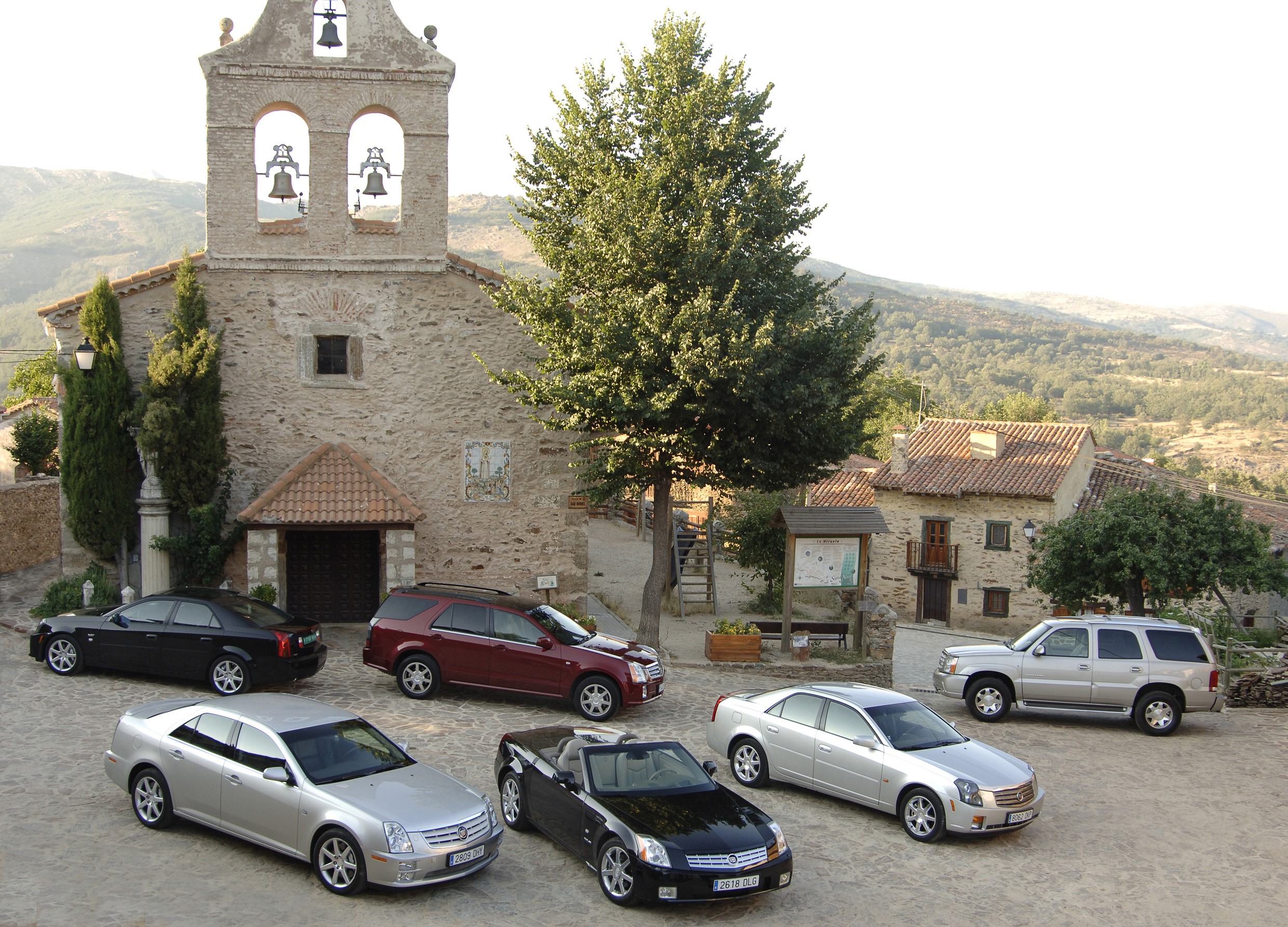 Cadillac cars parked in front of a stone church HD Wallpaper