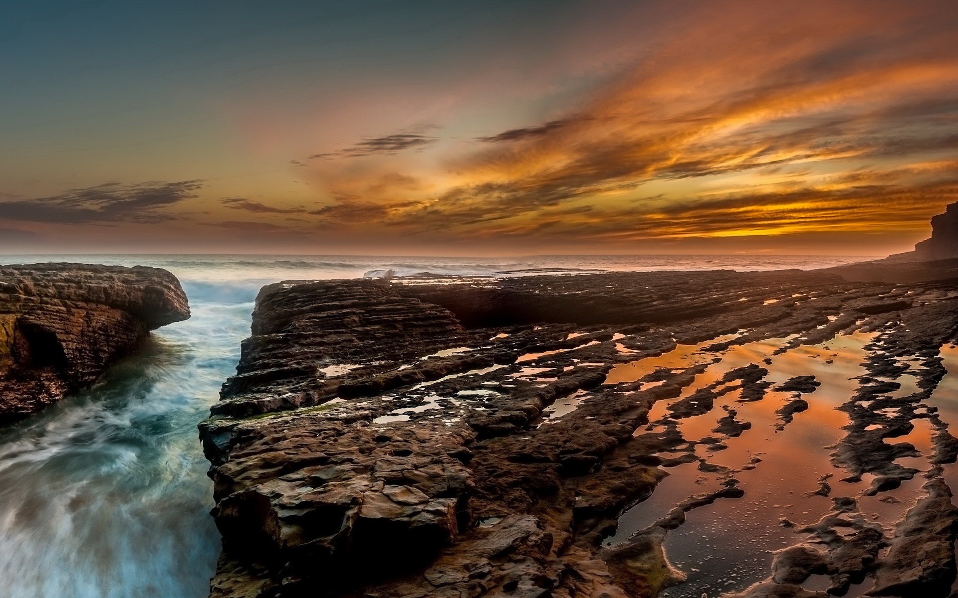 Rocky coastline with ocean waves at sunset HD Wallpaper