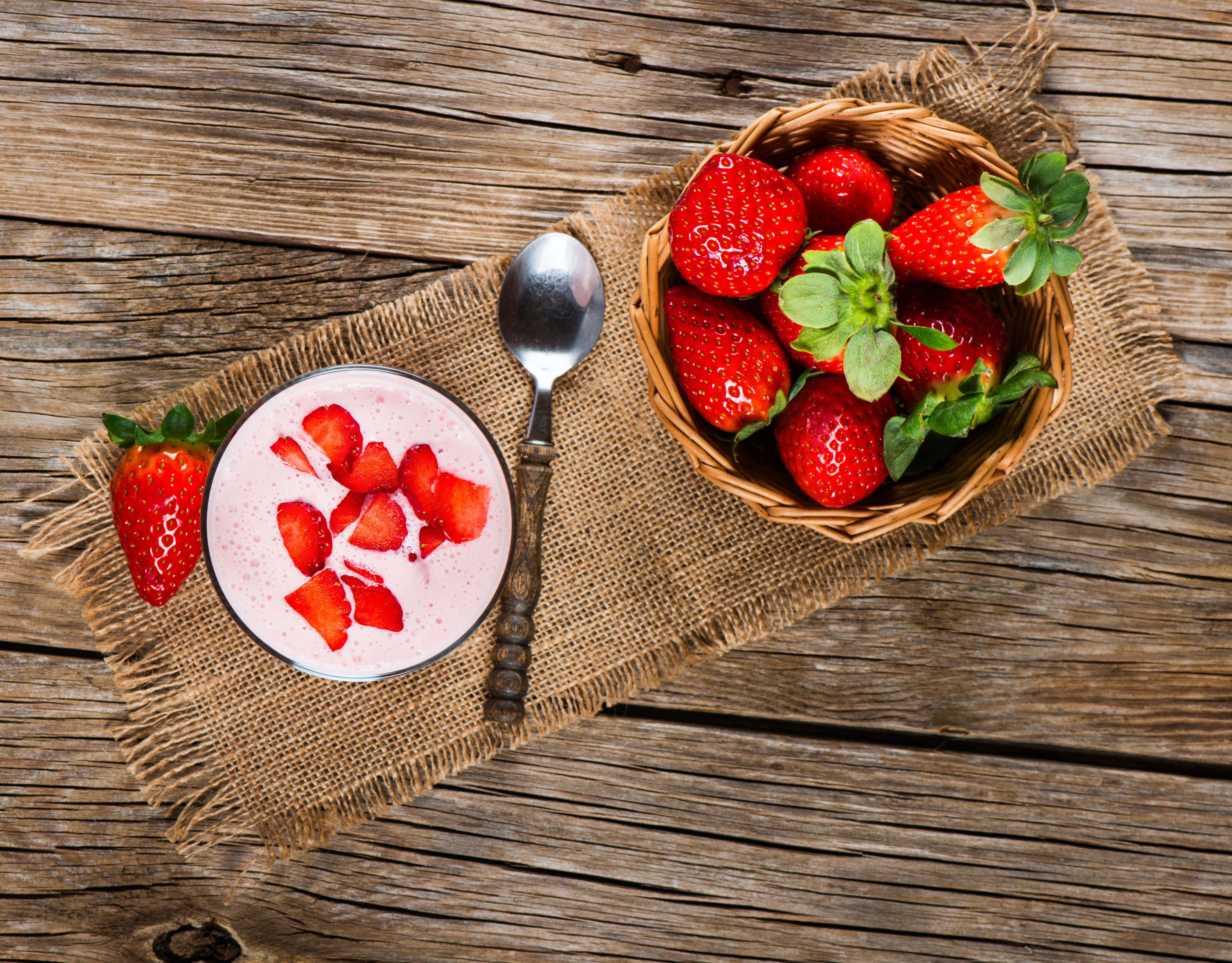 Strawberry yogurt in a glass with a spoon and basket of strawberries on wood HD Wallpaper