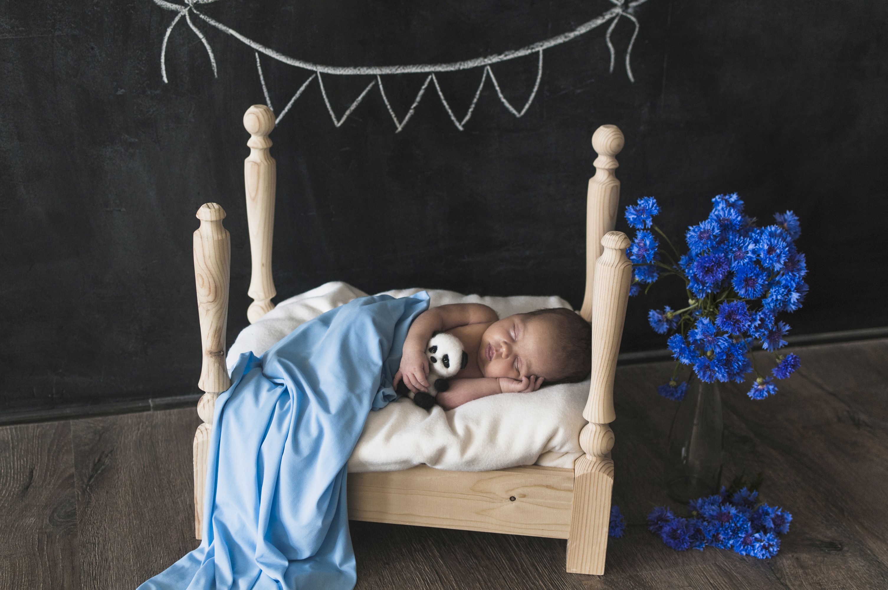 Newborn baby sleeping in a crib with a panda toy HD Wallpaper