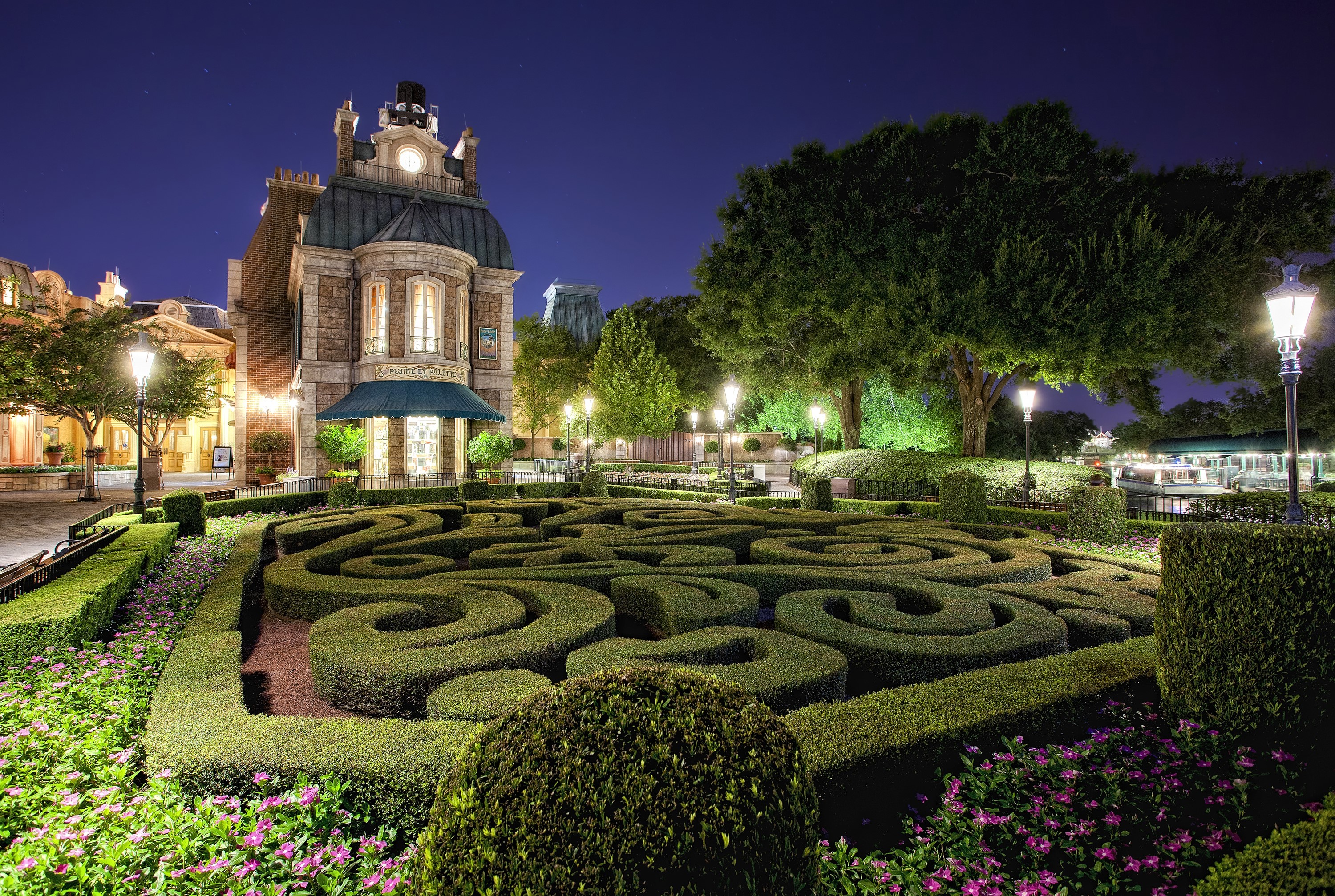 French-style building with a hedge maze at night HD Wallpaper
