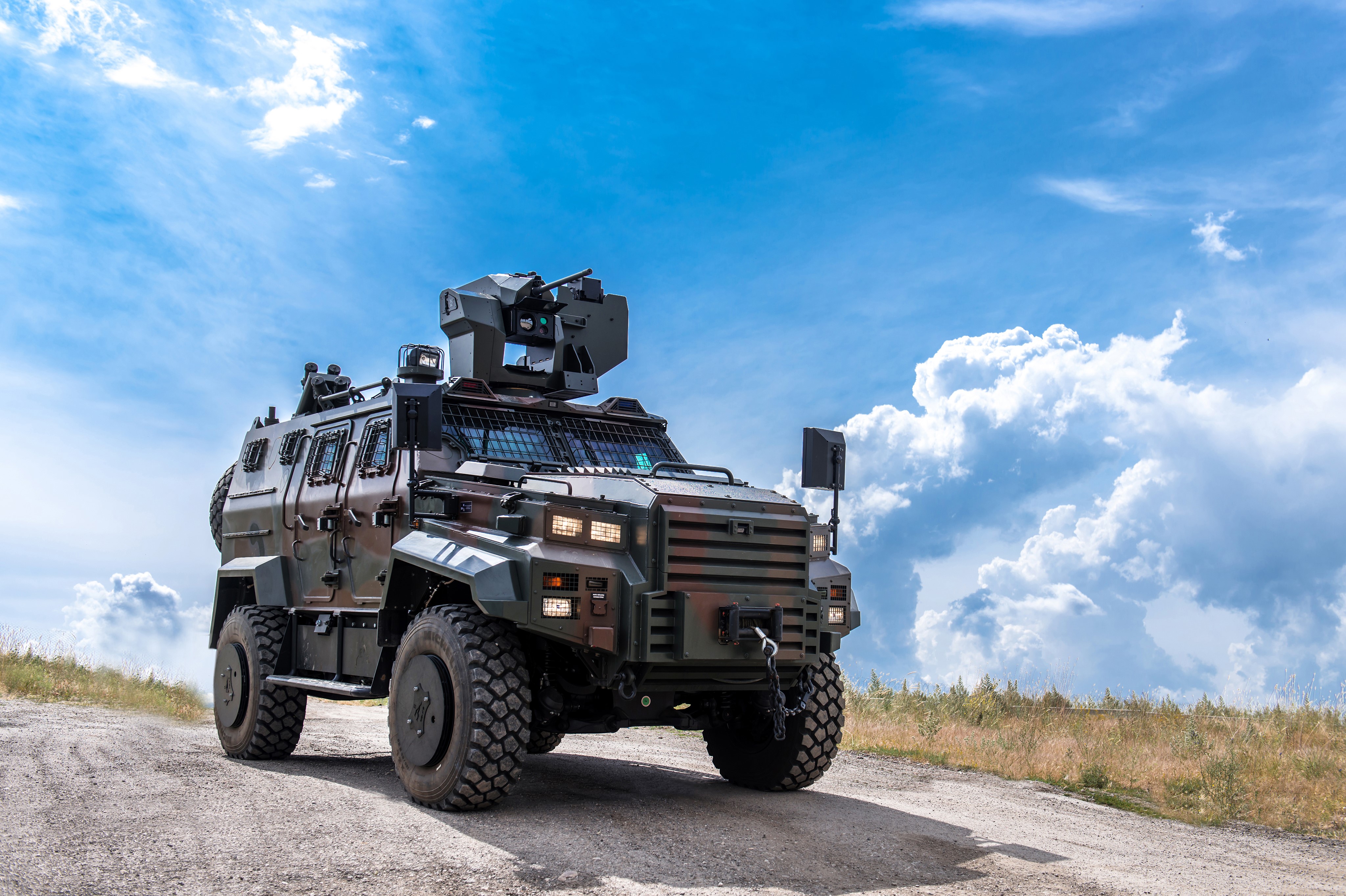 Military vehicle on a dirt road under a cloudy sky HD Wallpaper