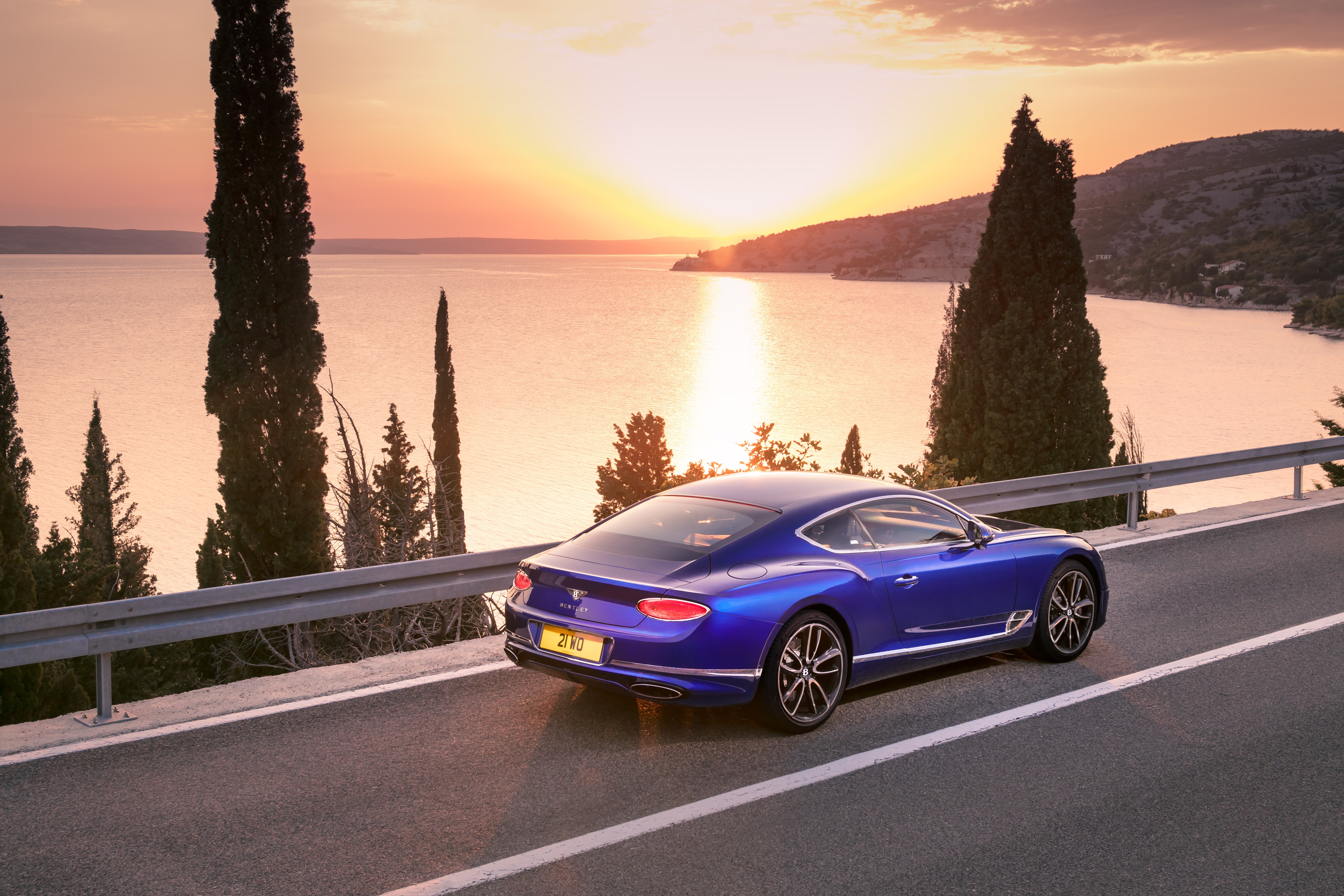 Blue Bentley Continental GT Coupe on Coastal Road at Sunset HD Wallpaper
