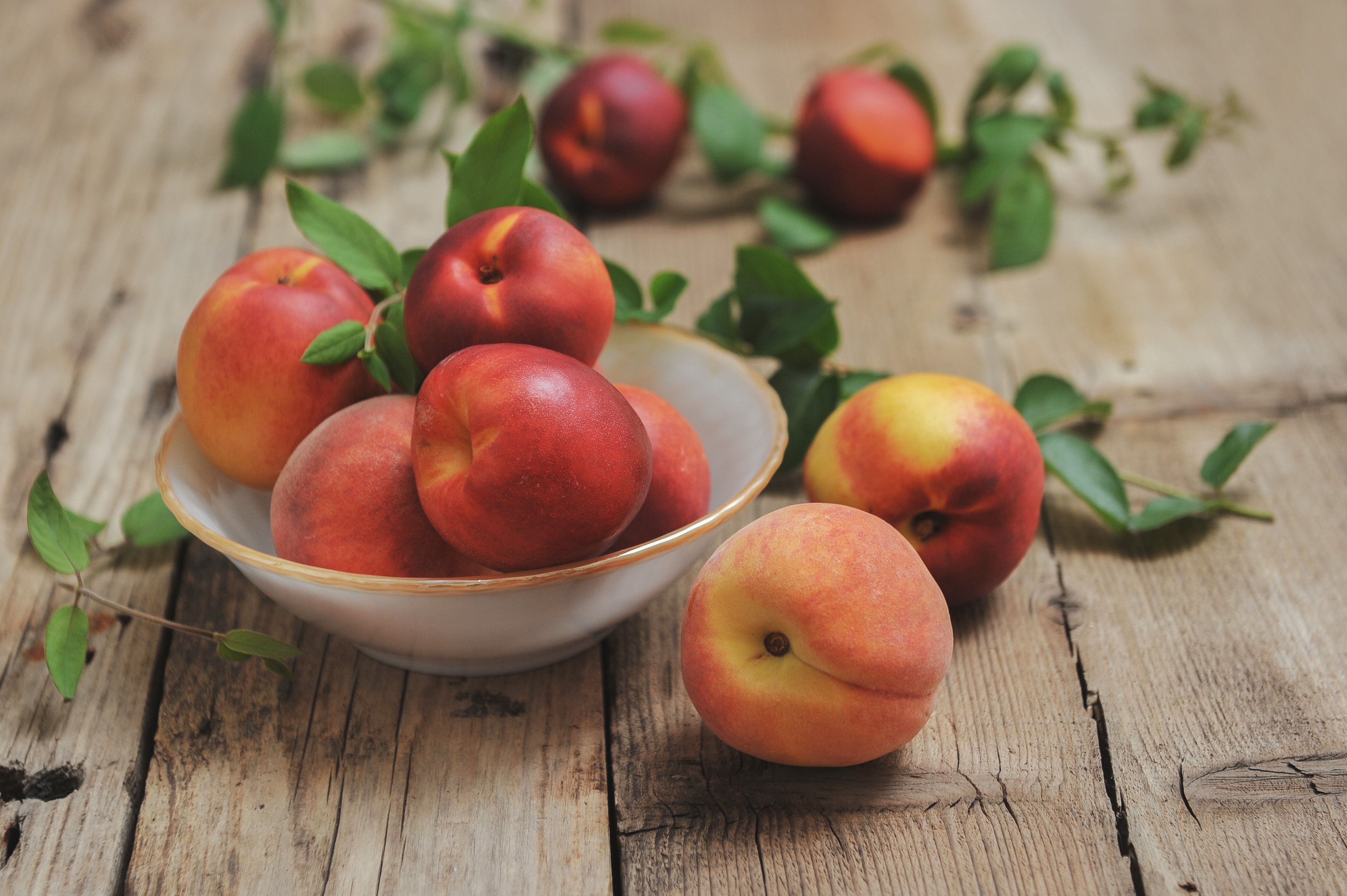 Peaches in a bowl on wood planks HD Wallpaper