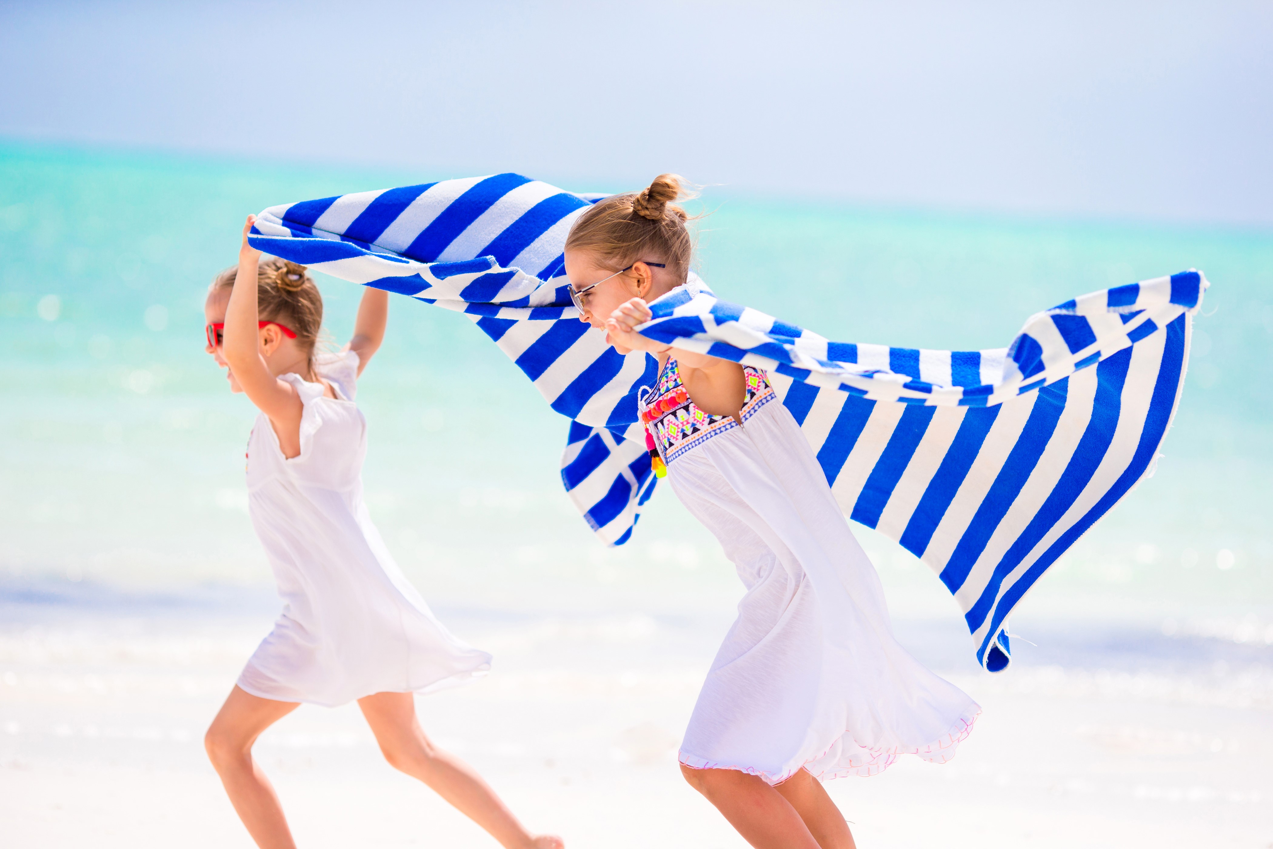 Two little girls running on the beach with a towel HD Wallpaper