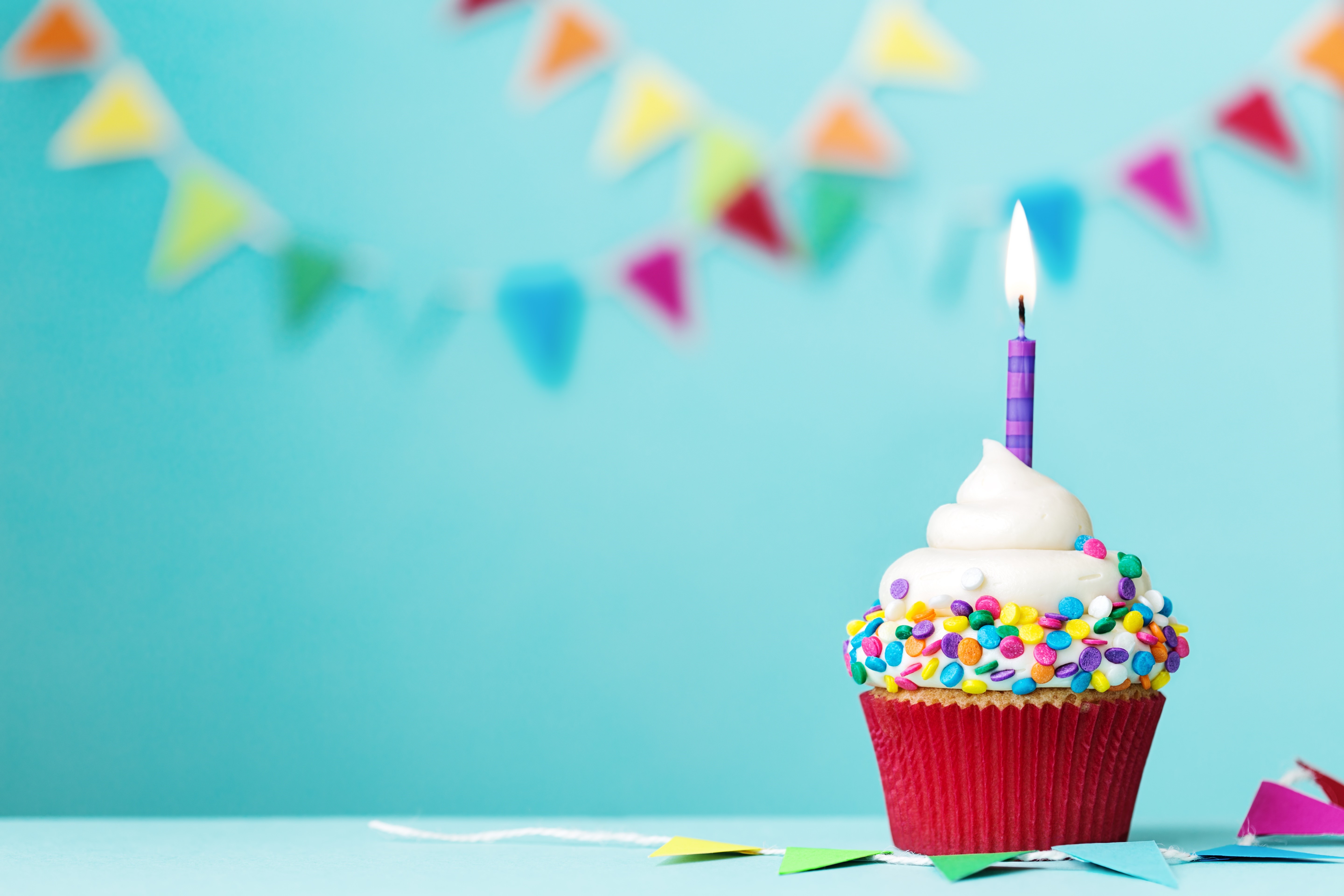 Cupcake with a lit candle and party flags HD Wallpaper